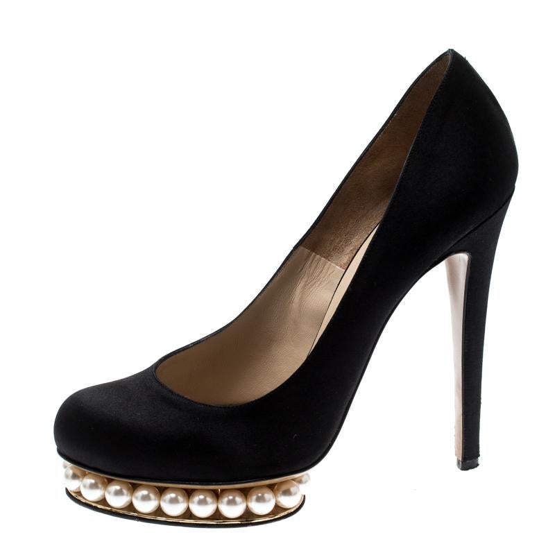 Step out in sophisticated style with these platform pumps from the luxury fashion house of Nicholas Kirkwood. They are crafted from satin and feature a classic black hue. They come with Casati faux pearls inlaid in the platforms, leather soles, and
