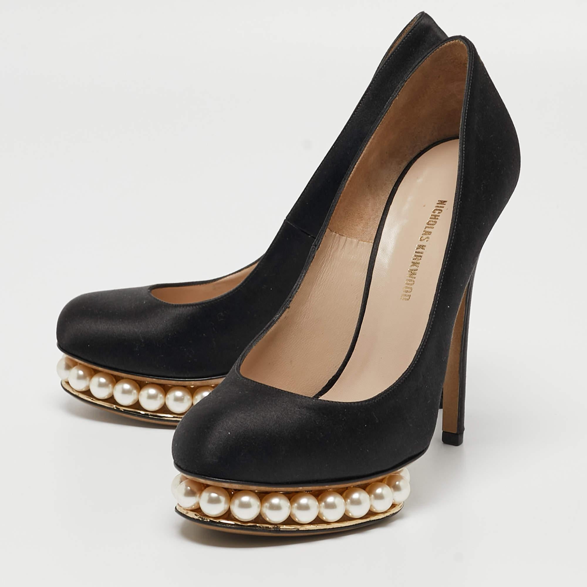 The Nicholas Kirkwood pumps exude elegance with their sleek black satin exterior and intricate pearl embellishments. These luxurious pumps seamlessly blend timeless sophistication with modern charm, making them a captivating choice for any formal