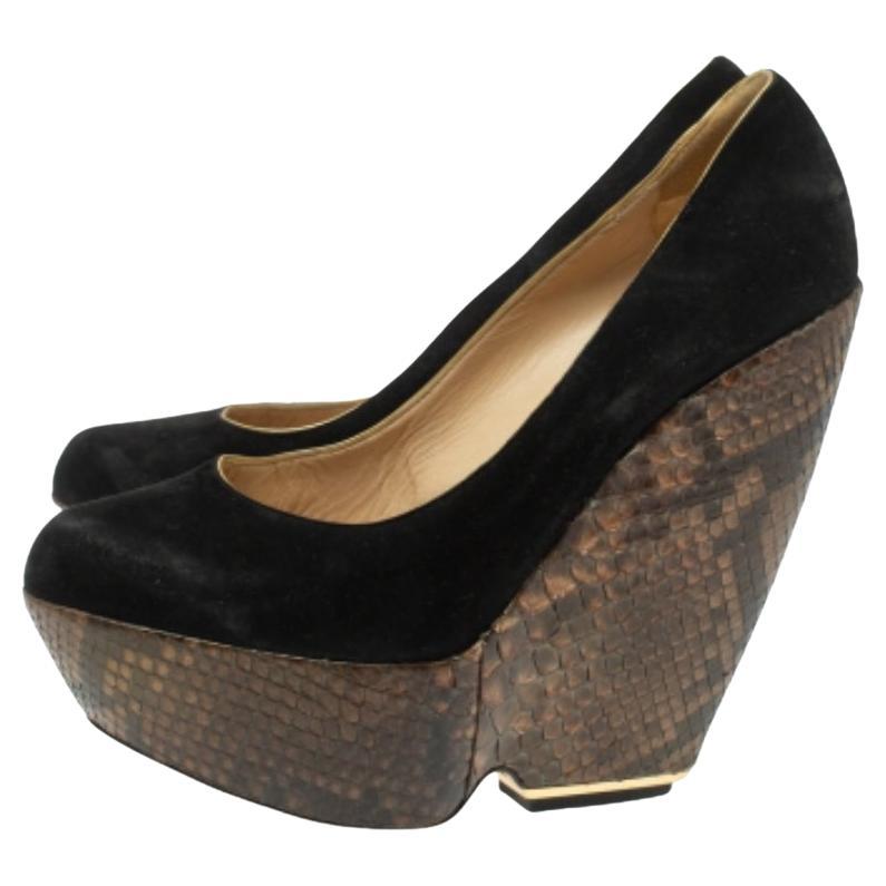 Make an elegant style statement in this pair of pumps from Nicholas Kirkwood. They are crafted from black suede and elevated on python leather wedge heels. Be it with dresses or simple casuals, these platform pumps will look lovely. (NOTE: FOR UAE