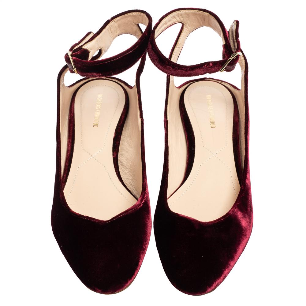 Take every step with elegance and confidence in these fabulous ballet flats from Nicholas Kirkwood. They are crafted using burgundy velvet and flaunt pearl-embellished heels. They have an ankle strap and gold-toned hardware. Match them with your