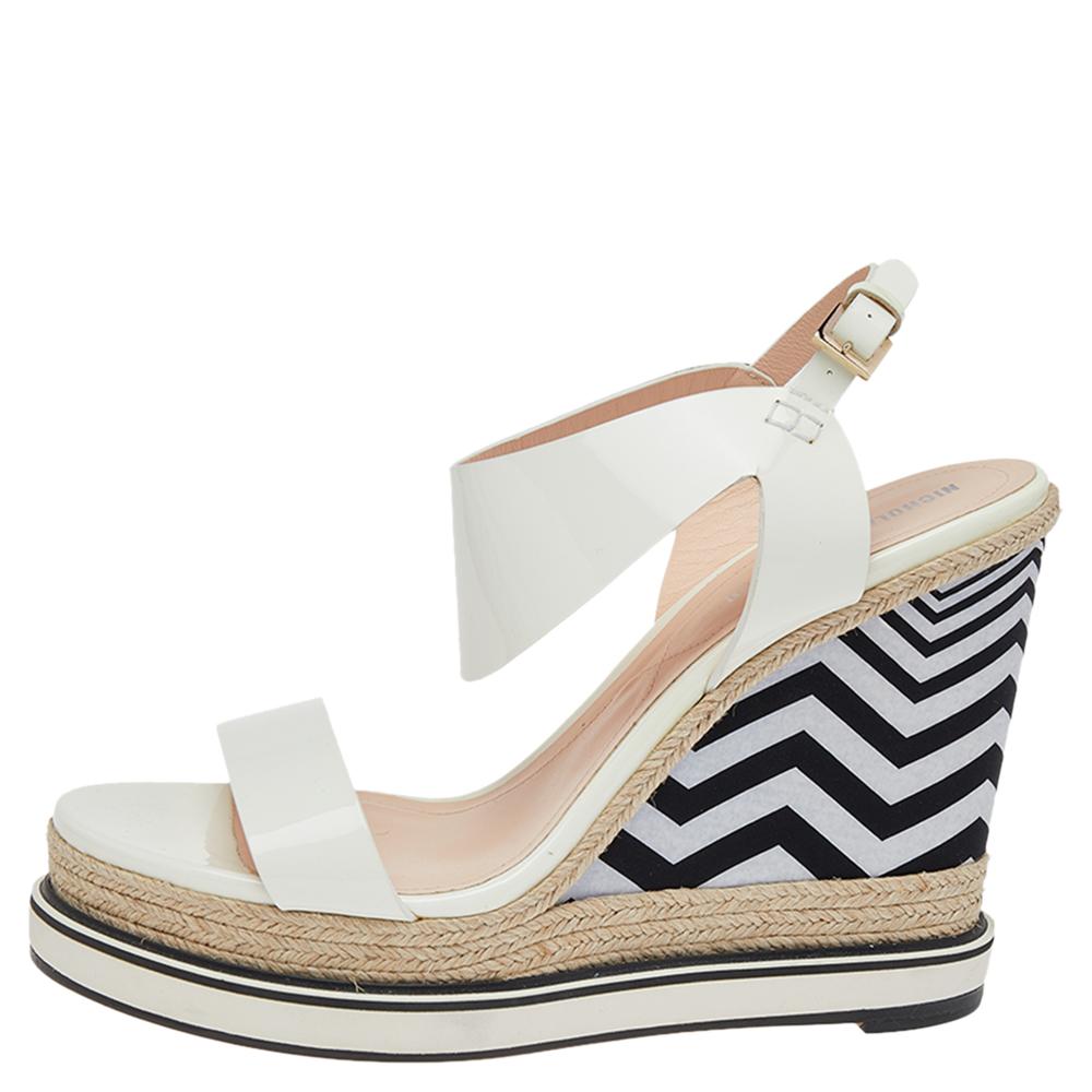 Complete a summer look with this pair of Nicholas Kirkwood sandals. Constructed using white patent leather, the open-toe sandals are secured with buckle closure at the ankles, lined with leather on the insoles, and lifted on fancy wedge heels that