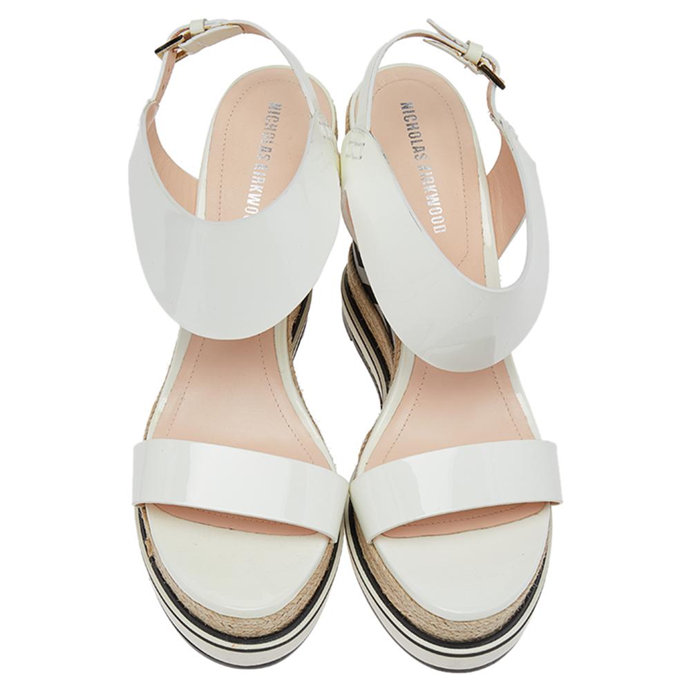 Complete a summer look with this pair of Nicholas Kirkwood sandals. Constructed using white patent leather, the open-toe sandals are secured with buckle closure at the ankles, lined with leather on the insoles, and lifted on fancy wedge heels that