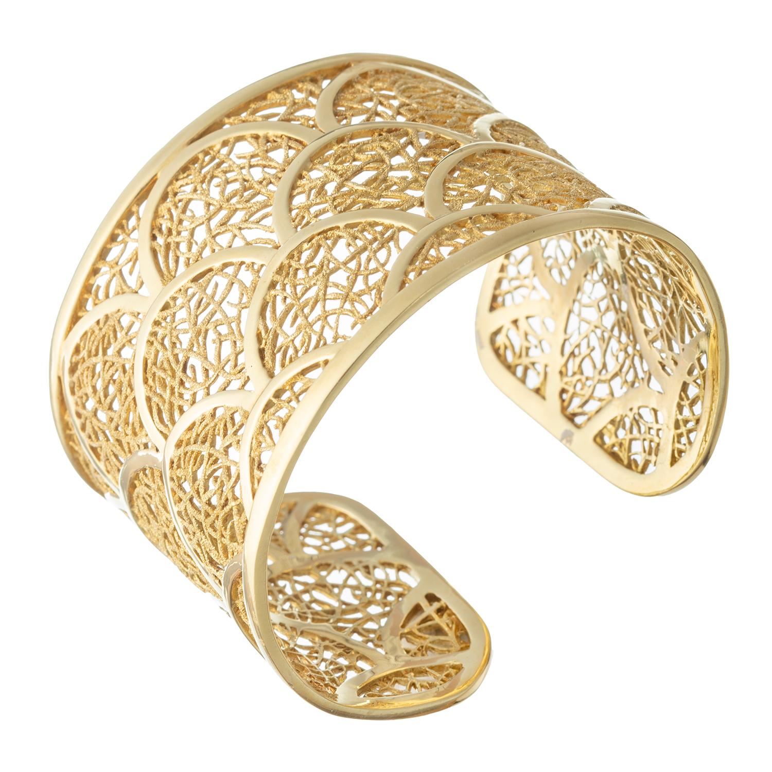 Indulge in the timeless beauty of the Nicholas Varney 18 karat gold Porto Nuevo cuff bracelet. This spectacular piece showcases an exceptional design featuring organic lattice sections joined by polished gold arches, creating a harmonious and