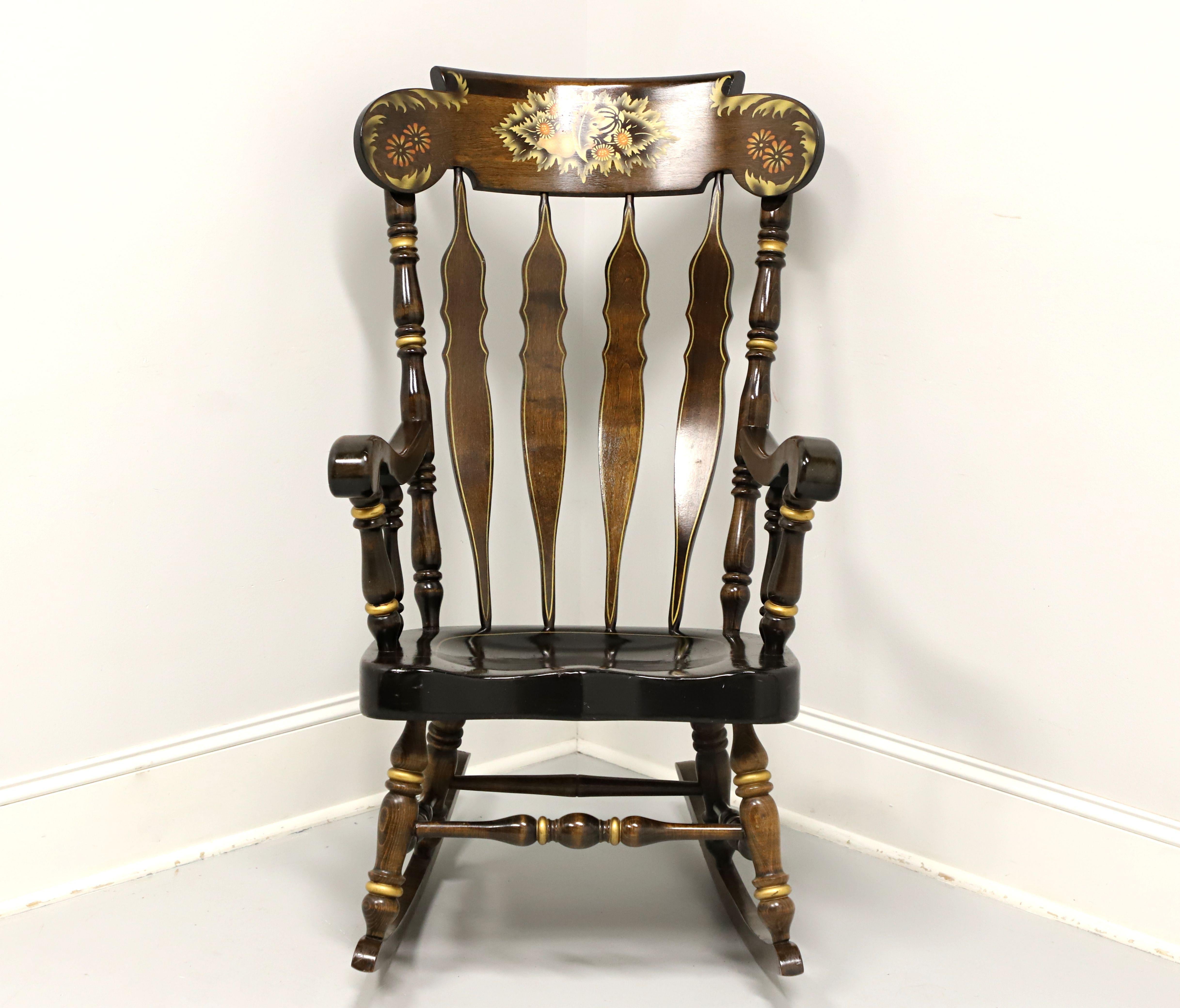 A stenciled Colonial Windsor style rocking chair by Nichols & Stone, possibly their Sugarbush. Select northern hardwoods with a pine seat, floral motif stenciling to carved crestrail, gold painted accents, decoratively carved backrest spindles,