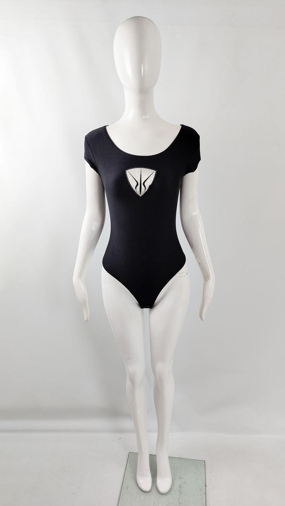 A vintage 90s women's bodysuit from British designer Nick Coleman's Shield label. Coleman was known for punk-inspired clubwear, this ribbed jersey piece features cap sleeves and Shield's bold silver logo embroidery on the front.

Size: Marked M but