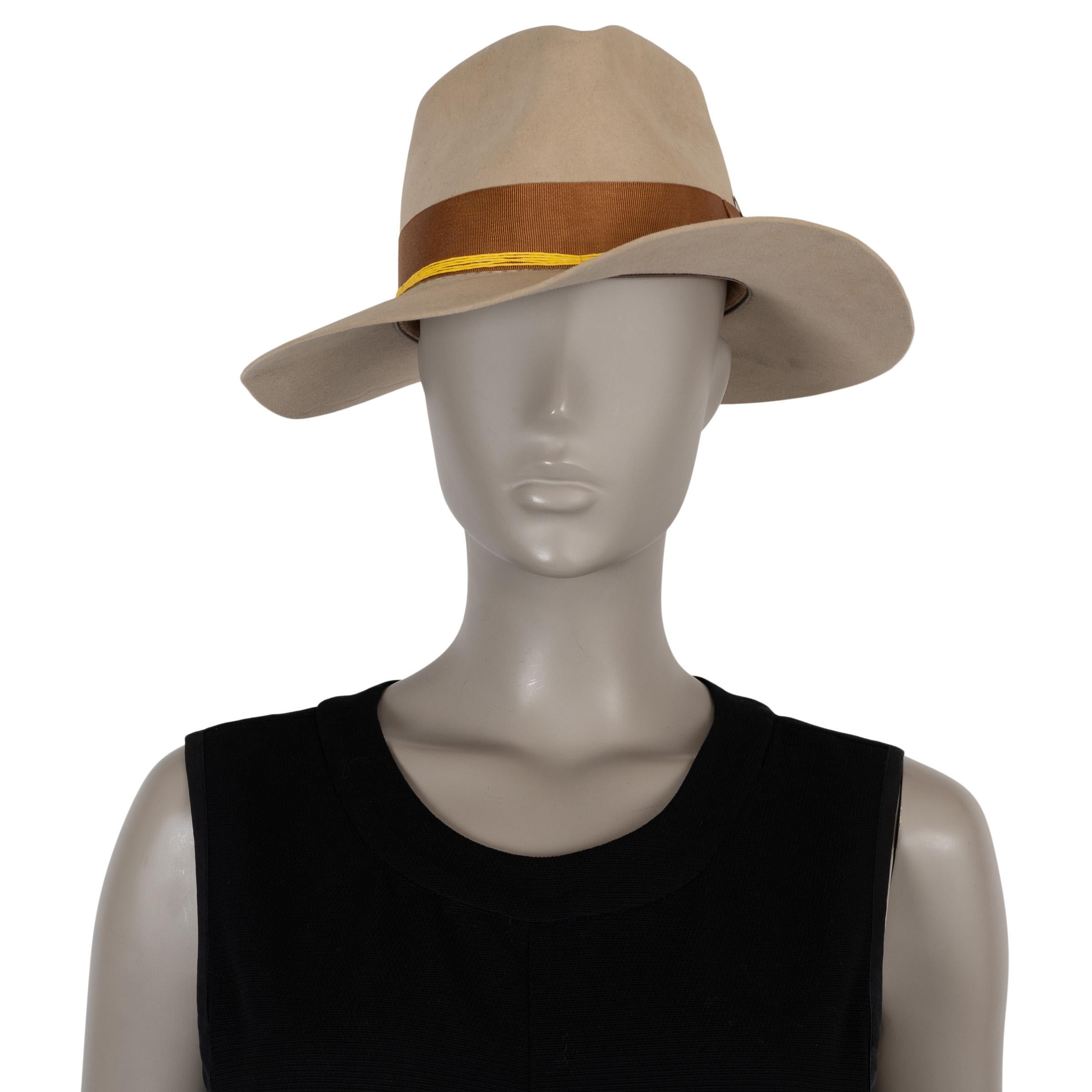 Questo cappello fedora di Nick Fouquet, autentico al 100%, è realizzato in feltro di castoro grigio pietra sabbia (100%). Presenta una classica silhouette a fedora con tesa larga, arricchita da un nastro in gros grain marrone e da una fascia in