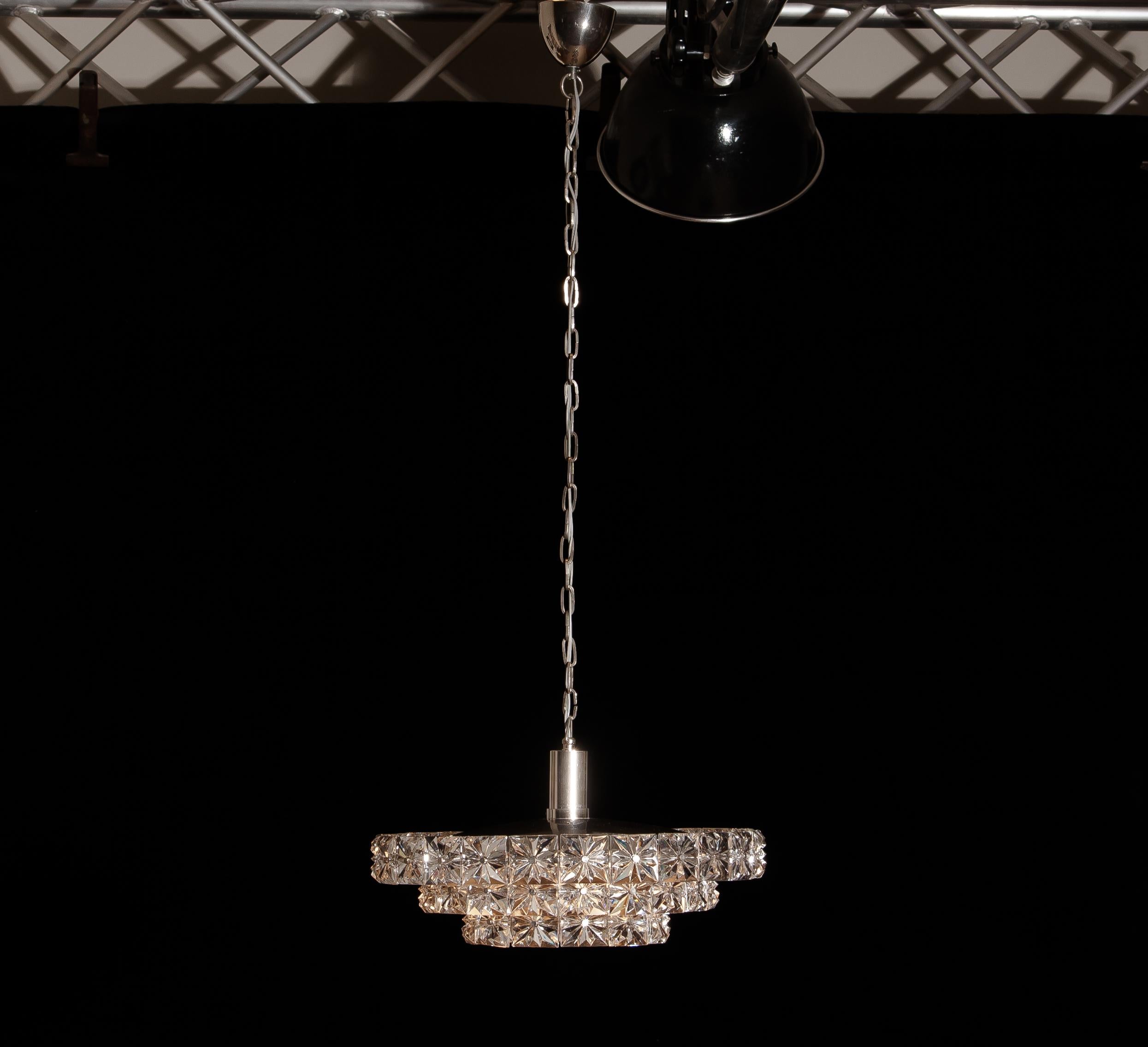 Extremely beautiful three-tier nickel and chrome clear crystal chandelier by Kinkeldey, Austria.

Wired for 110 and 220 volts. Contains six sockets normal size.
Period: 1960
The measurements of the chandelier: ø 40 cm, height 20 cm. Total height