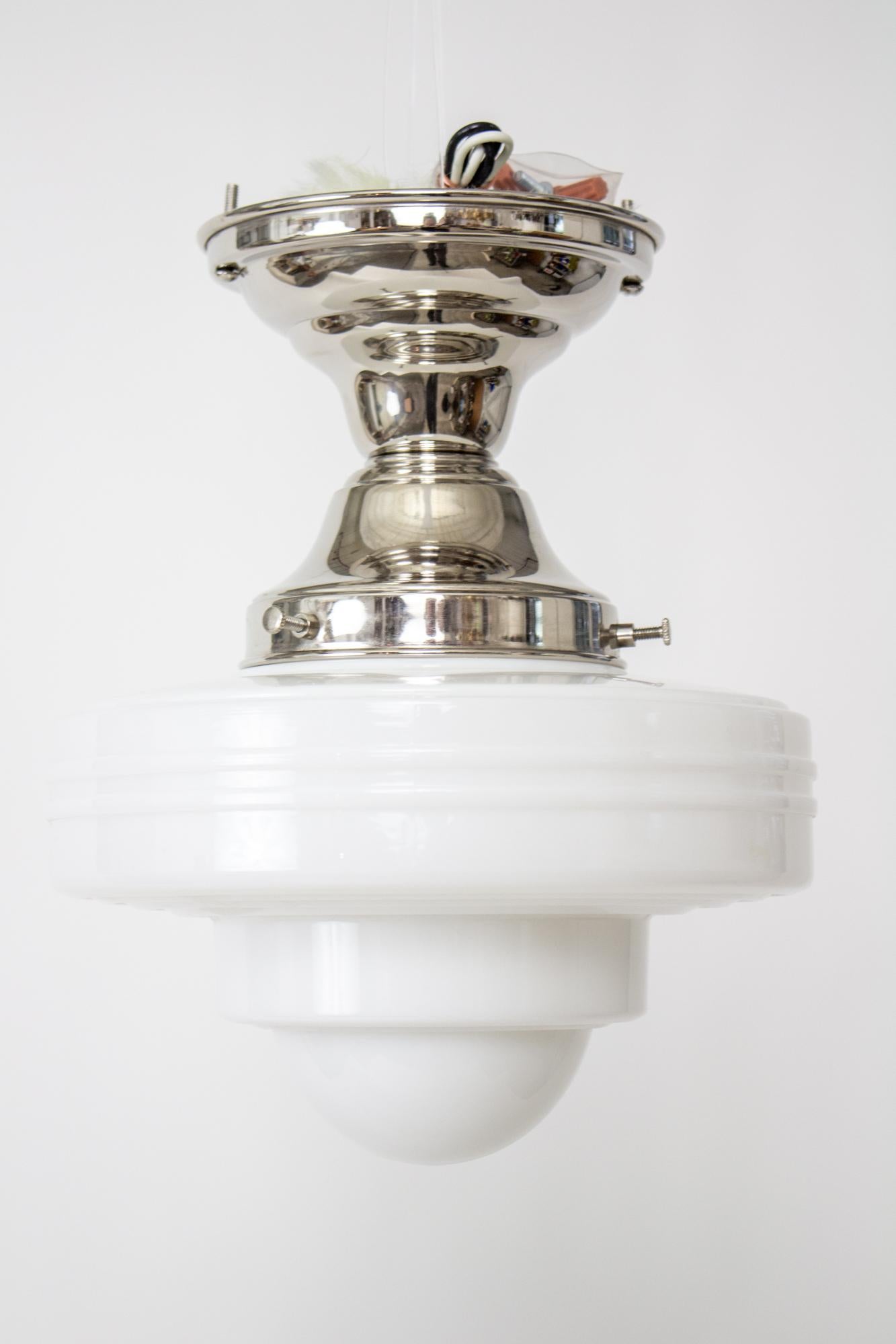 Art Deco UFO style milk glass mounted on a new polished nickel fixture. Excellent for use in a hallway, kitchen, or bathroom. Glass is american, circa 1930. Ribbed with a domed bottom. Excellent condition. Single Edison base socket, 60 watt max.