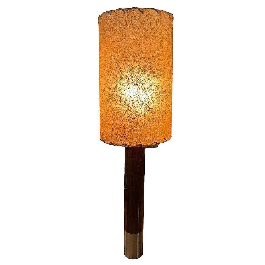 Lampe de table Nickel Básica M2 de Santiago Roqueta pour Santa & Cole avec abat-jour tambour. Elle se compose d'un cylindre en bois d'acajou soutenu par une base métallique robuste, complétée par un abat-jour original en fibre de verre à points de