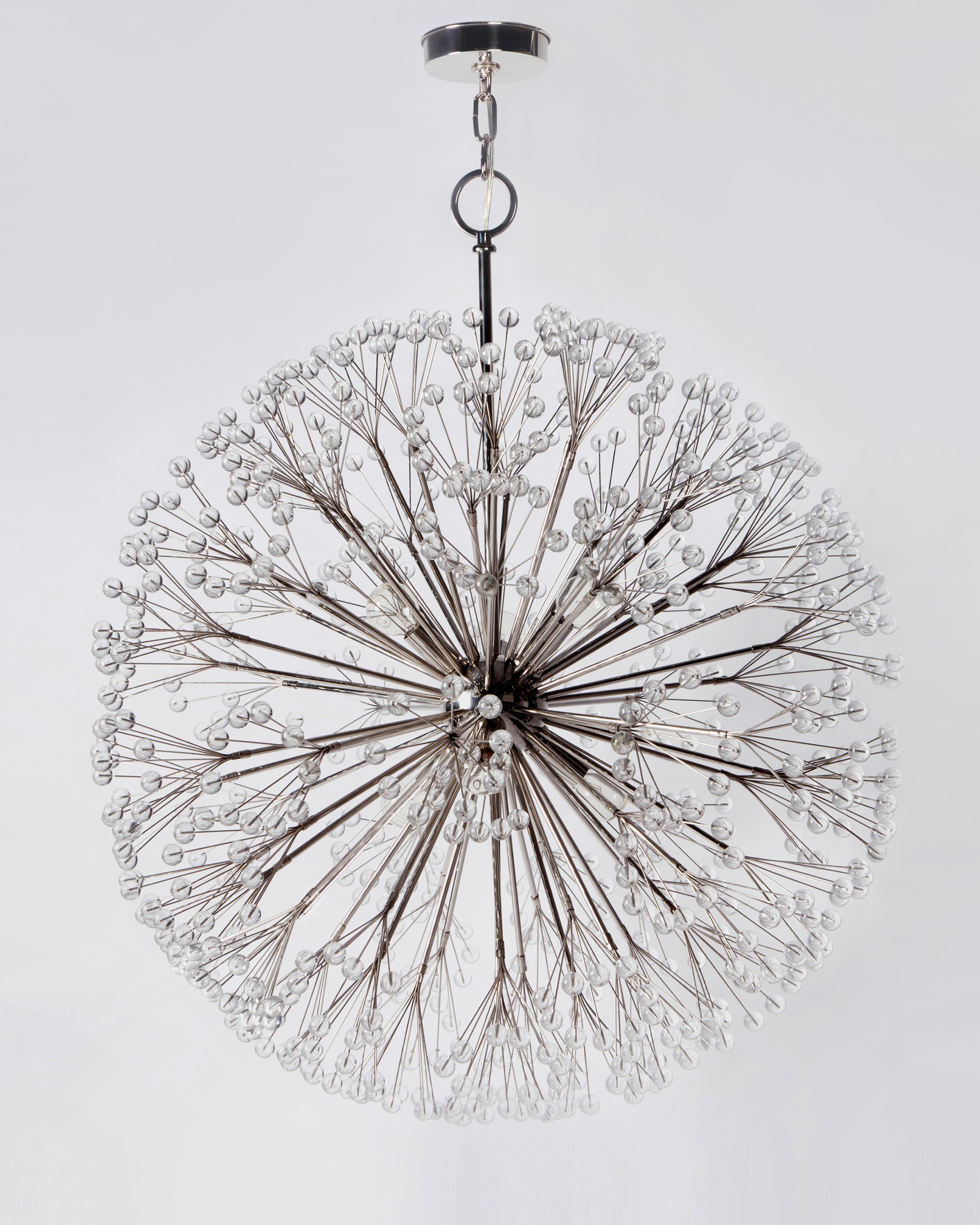 DC4610.32
The polished nickel Dandelion 32 chandelier is a solid brass sputnik style ceiling fixture gaining its delicate and organic circular shape from sprays which emanate from a central sphere, each sprig tipped with a polished lucite ball,