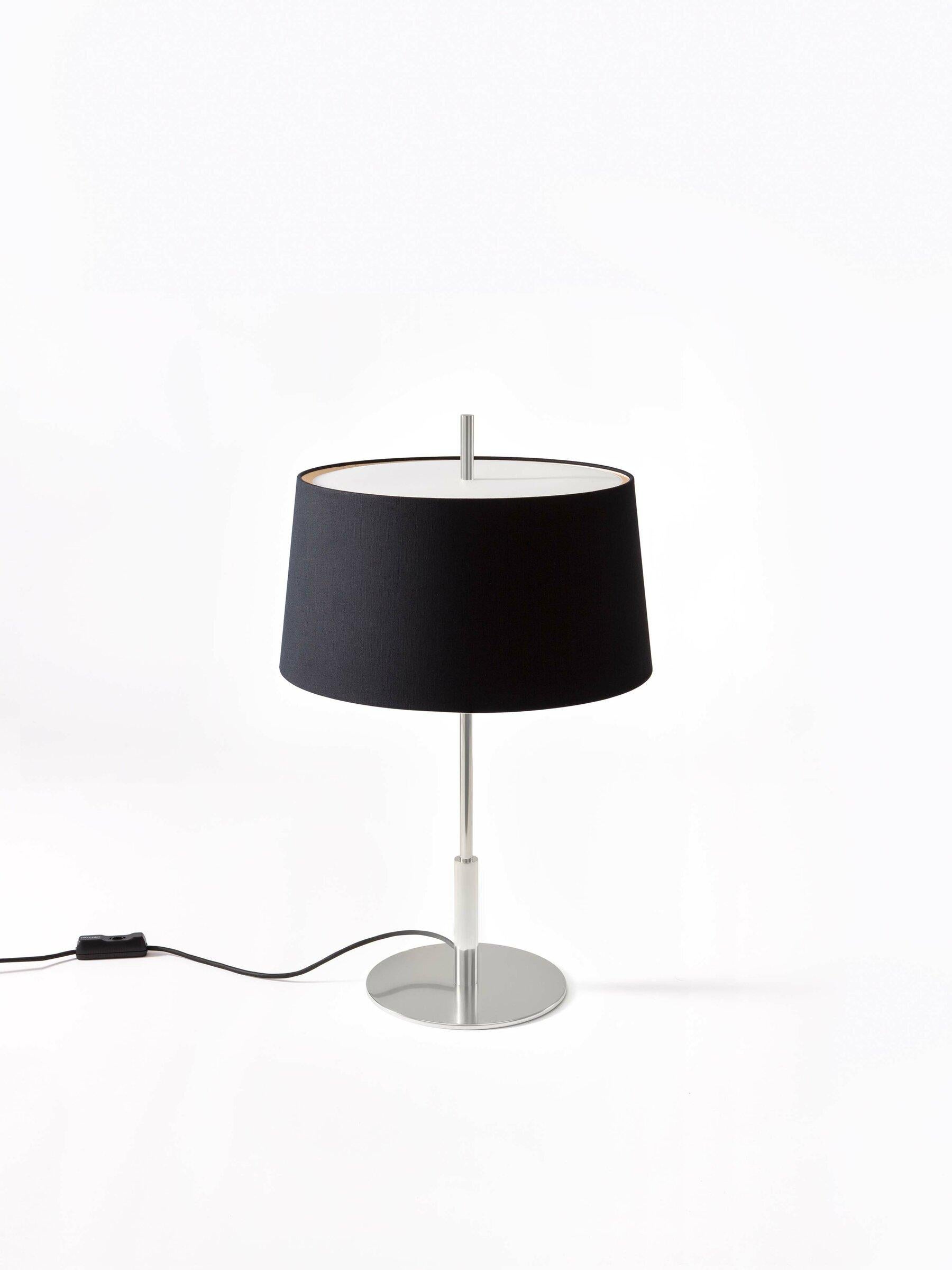 Lampe de table Diana Menor en nickel de Federico Correa, Alfonso Milá, Miguel Milá
Dimensions : D 40 x H 66 cm.
Matériaux : lin noir, nickel.
Disponible en abat-jour noir ou blanc et en finition or ou nickel.

Conformément à la vocation de ses