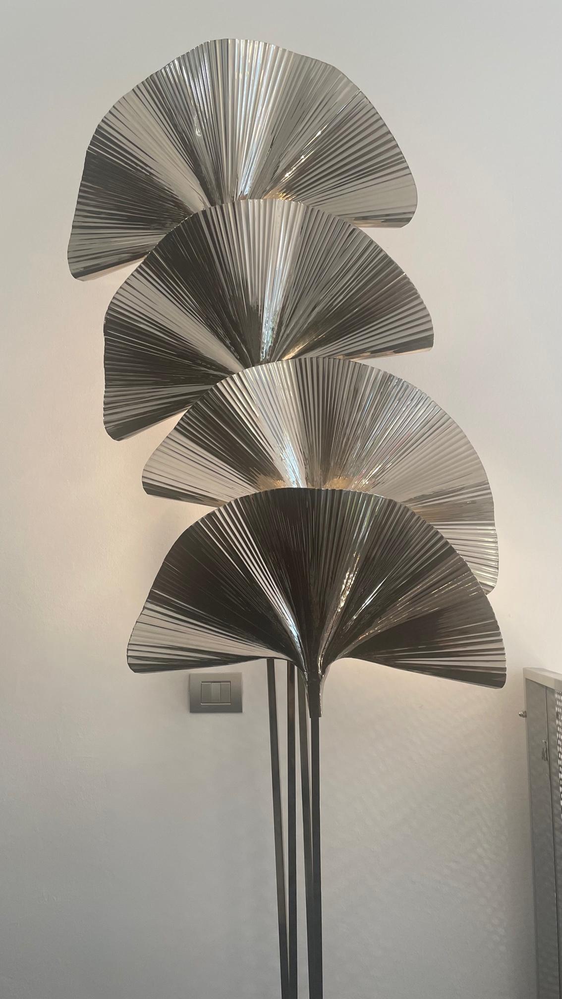 The Italian floor lamp made entirely of 21st century nickel-plated brass. The lamp is a modern and elegant lighting option. The great special feature of the lamp are its nickel-plated brass leaves that act as light covers and give an almost tropical
