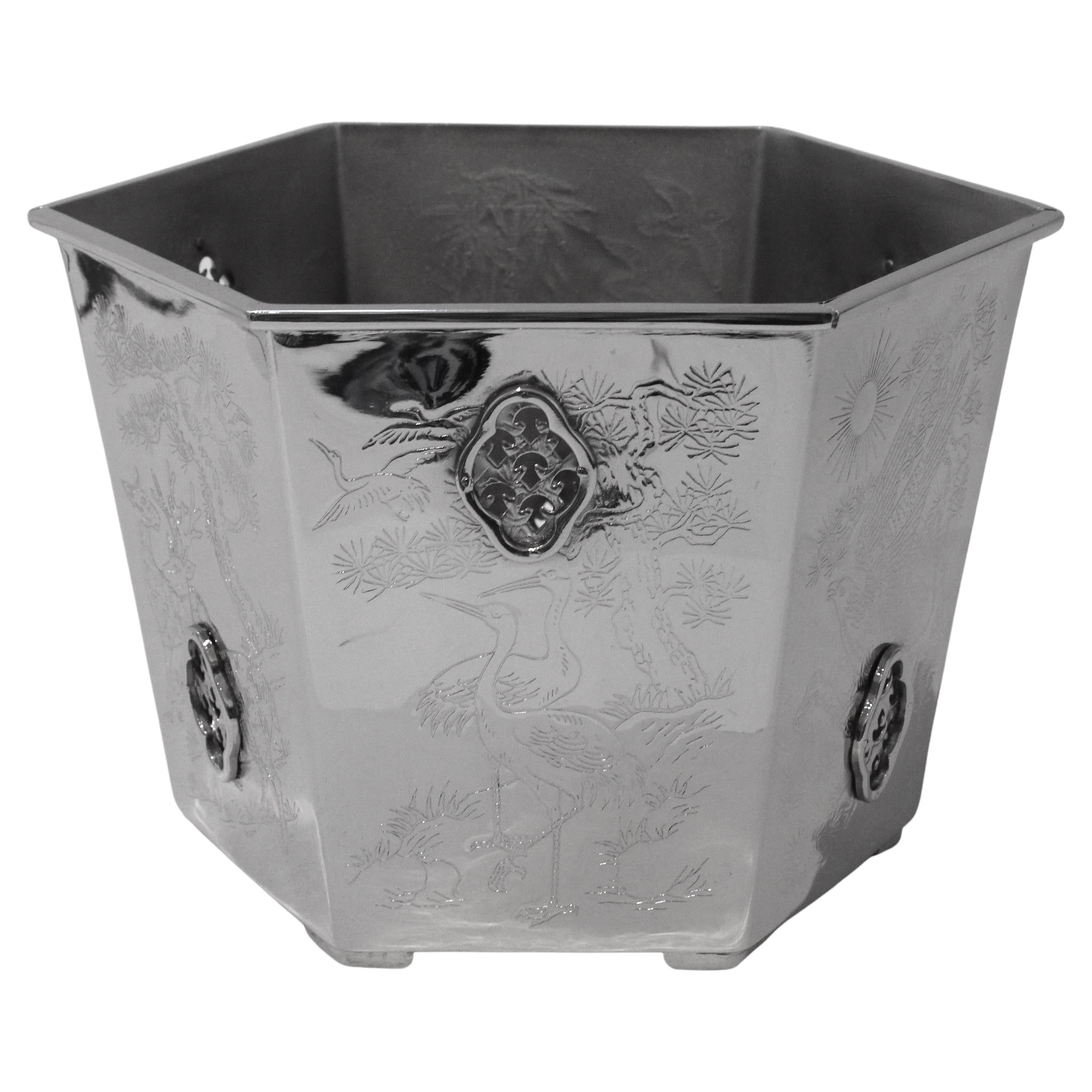 This stylish and chic nickel plated cachepot originally dates to the 1960s and has recently been plated in nickel for a fresh modern look.

The hexagonal shape is detailed with pierced cartouches and idyllic asian scenes. 

Note: The pierced