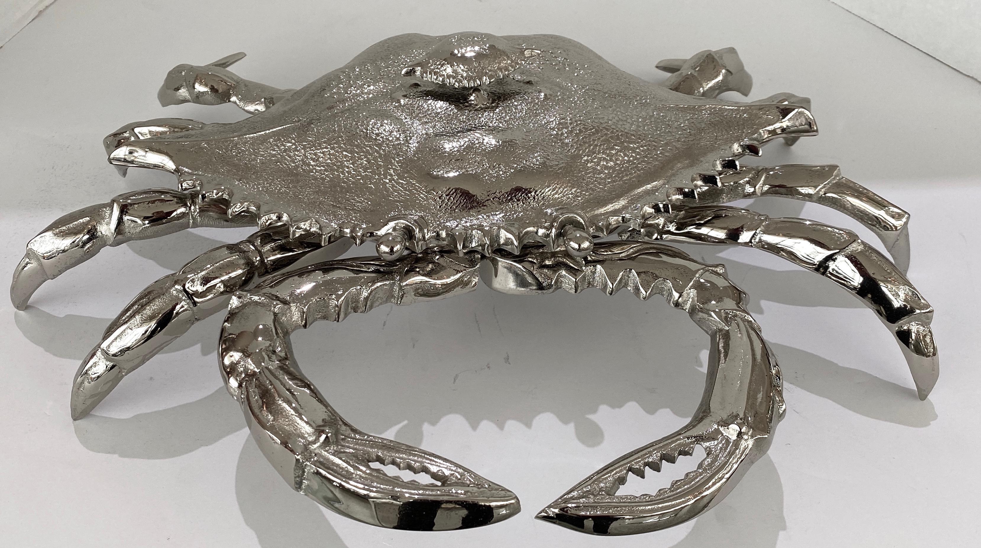 This stylish, and chic life size crab form dish is part of a collection of nickelplated objects and figures created by the firm of Angel & Zevallos of the Palm Beaches. 

Note:  There is a similar one but with a hinged carapace lid on another of our