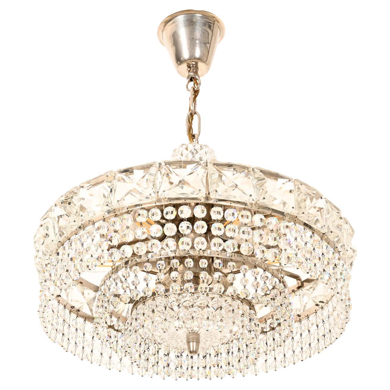 Lampadario in ottone e cristallo tagliato realizzato negli anni '60.
Cornice in ottone dotata di sei prese E14, ricca di pendenti dai vari cristalli sfaccettati.