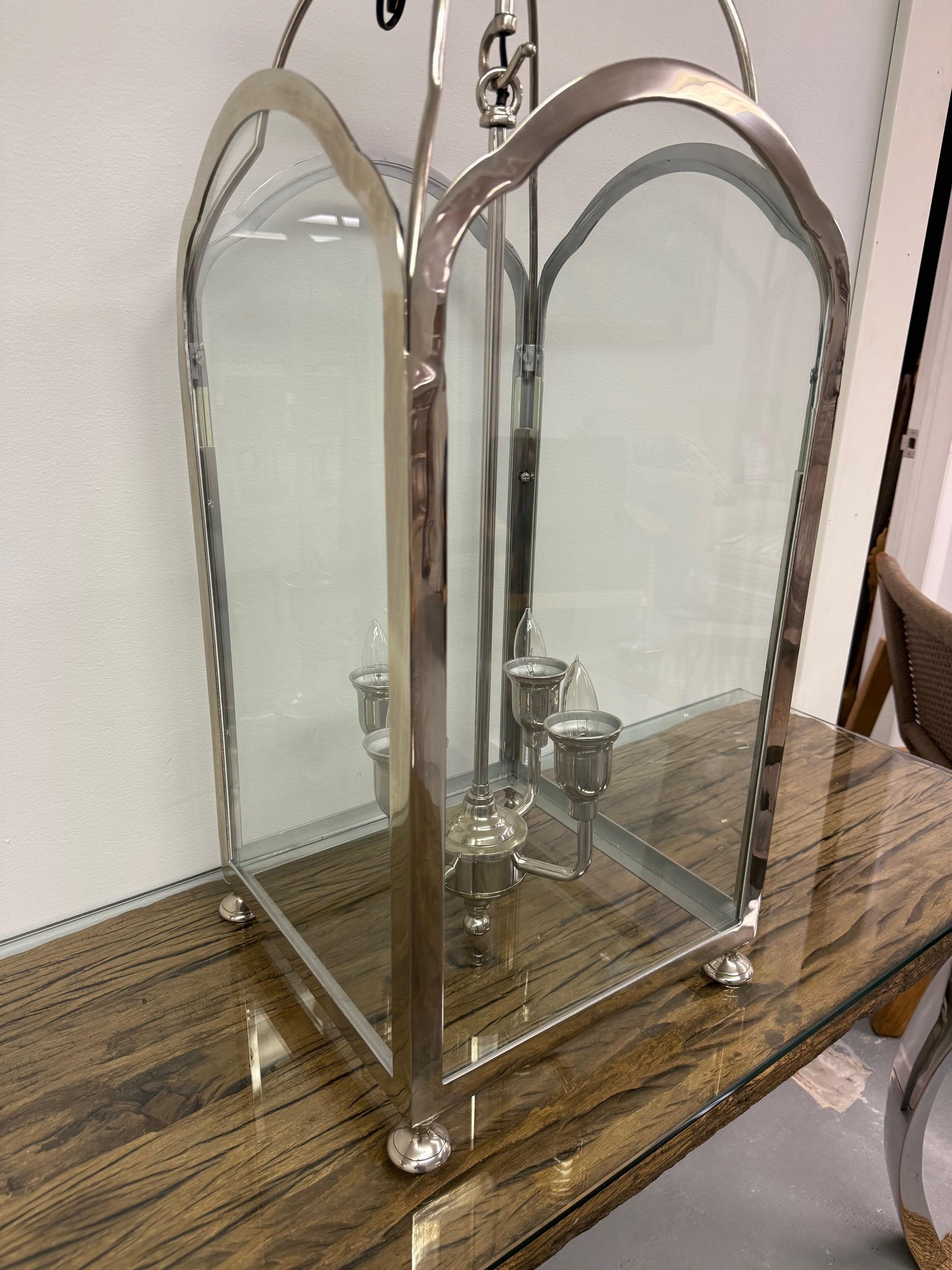 Wunderschöner vernickelter Kronleuchter im Laternenstil mit vier gewölbten Glasscheiben und vier Lichtern in der Mitte. Dieser Laternenkronleuchter verbindet klassischen Charme mit moderner Vielseitigkeit. Die gewölbte Platte und der schlanke