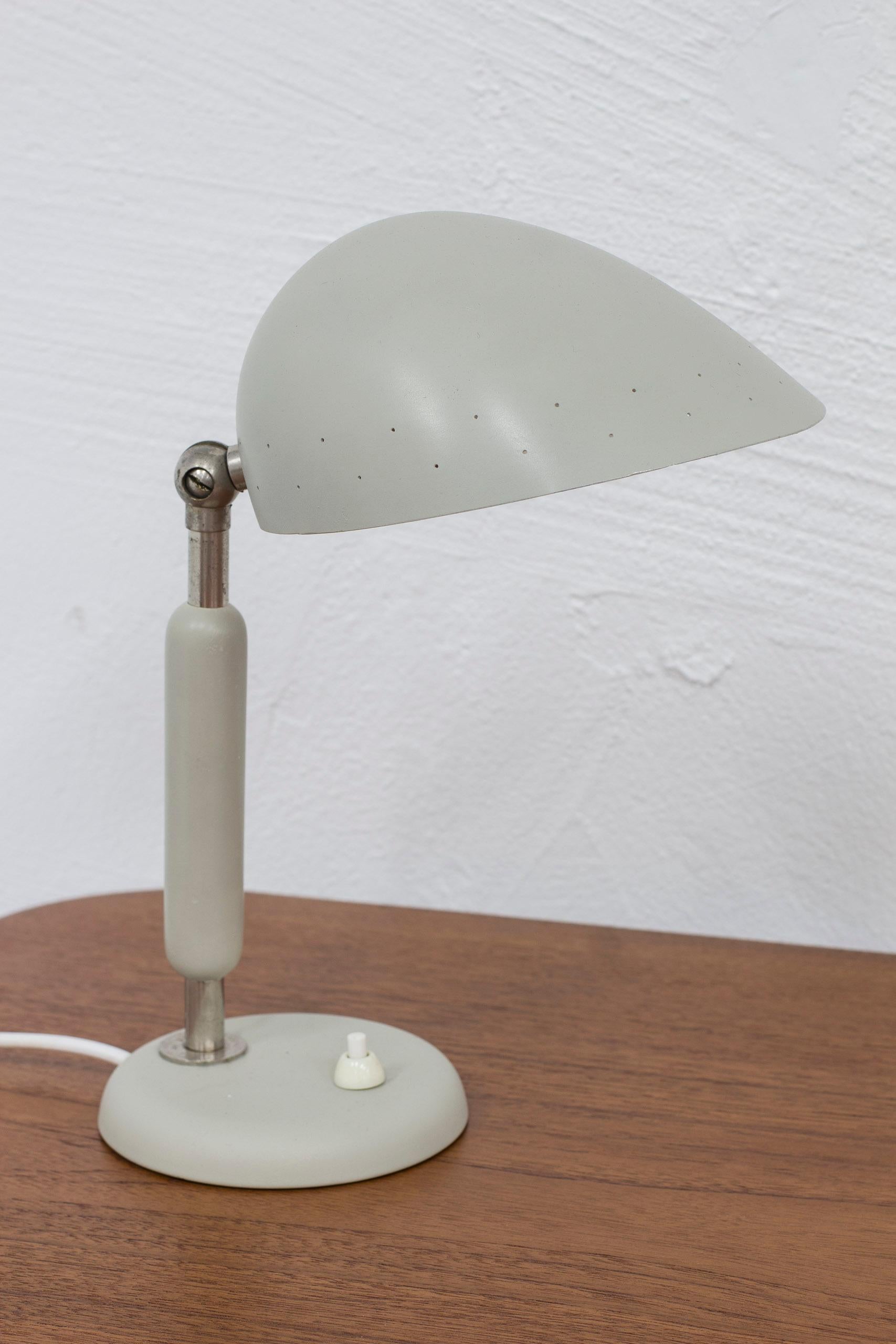 Table lamp designed by Harald Notini. Produced in Stockholmn, Sweden by Böhlmarks lampfabrik during the 1940-50s. Made from nickel plated metal, lacquered wood and aluminum. Light switch on the base in working order. Adjustable shade. Good vintage