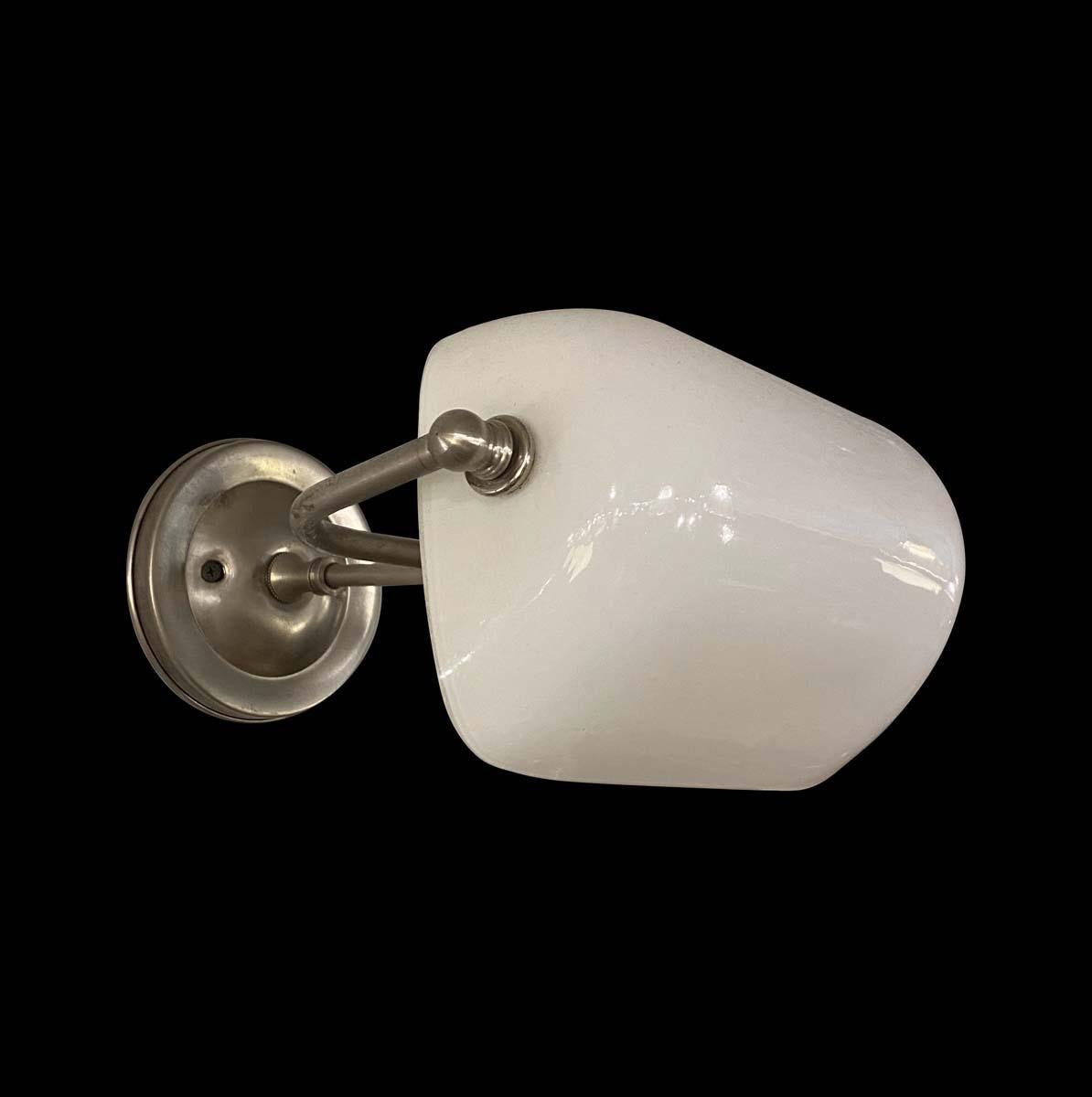 1980s nickel plated white milk glass banker wall lamp sconce is a unique find from a closed Linen store on the Upper East Side, NYC. Custom made, these lights exude timeless elegance and history. Cleaned and restored. This requires one standard