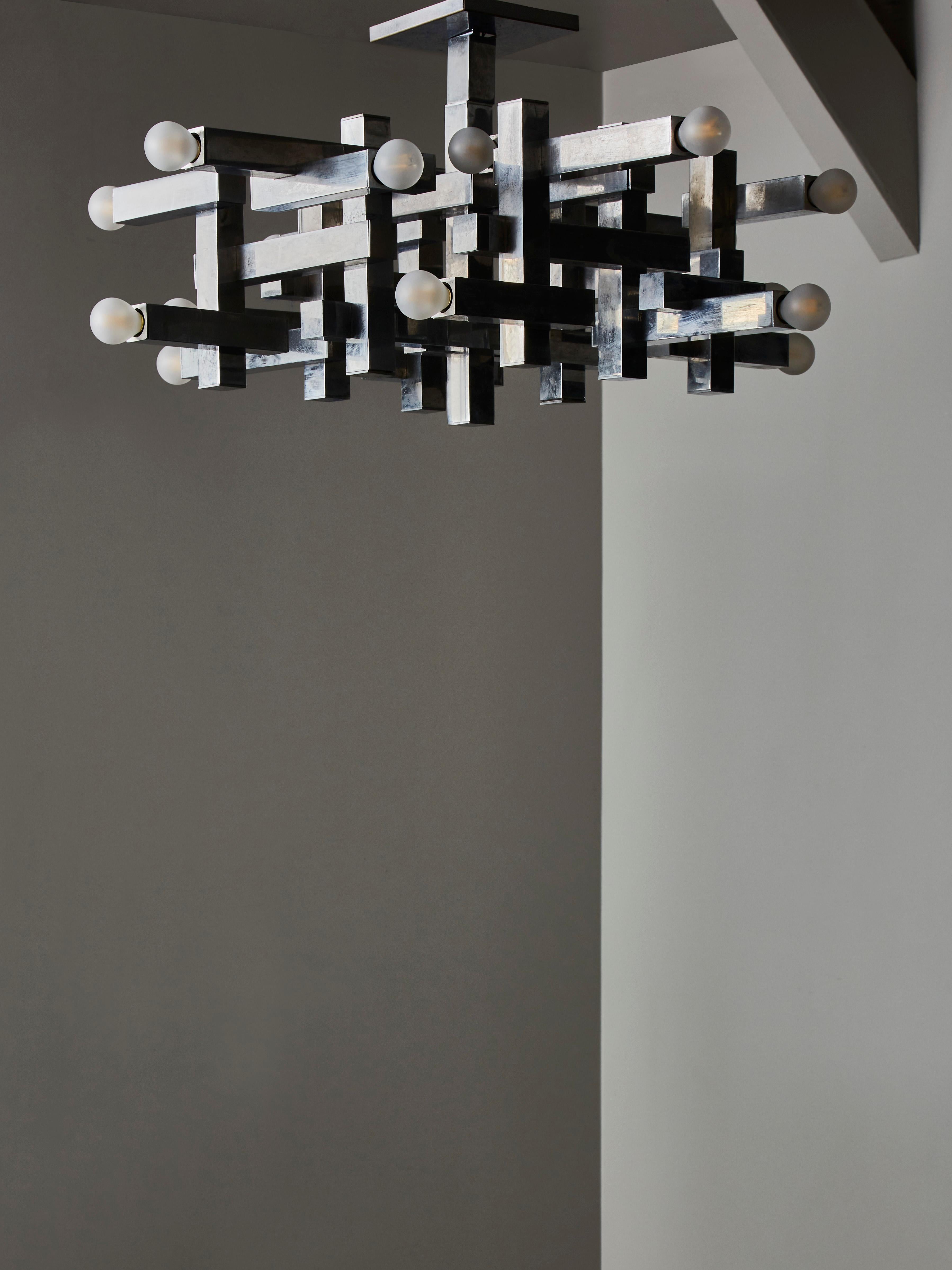 Cubist chandelier by Gaetano Sciolari made of square tubes geometrically assembled.

Original sticker in the canopy.