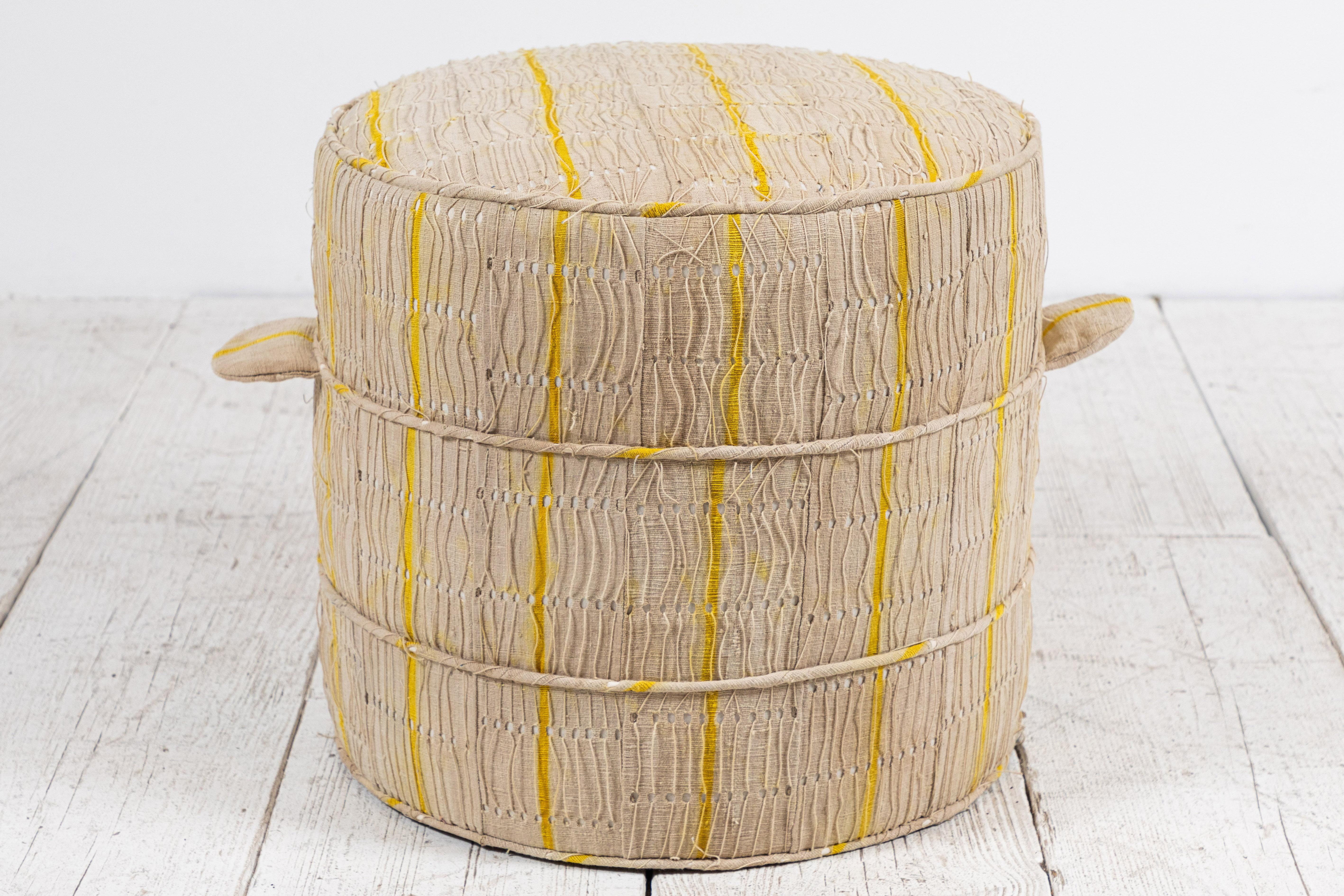 Solid wood frame and upholstered hassock with two ring piping and double handle details offers versatility in accent seating. Please enquire regarding custom sizes.

This specific Hassock is upholstered in a one of a kind African natural and