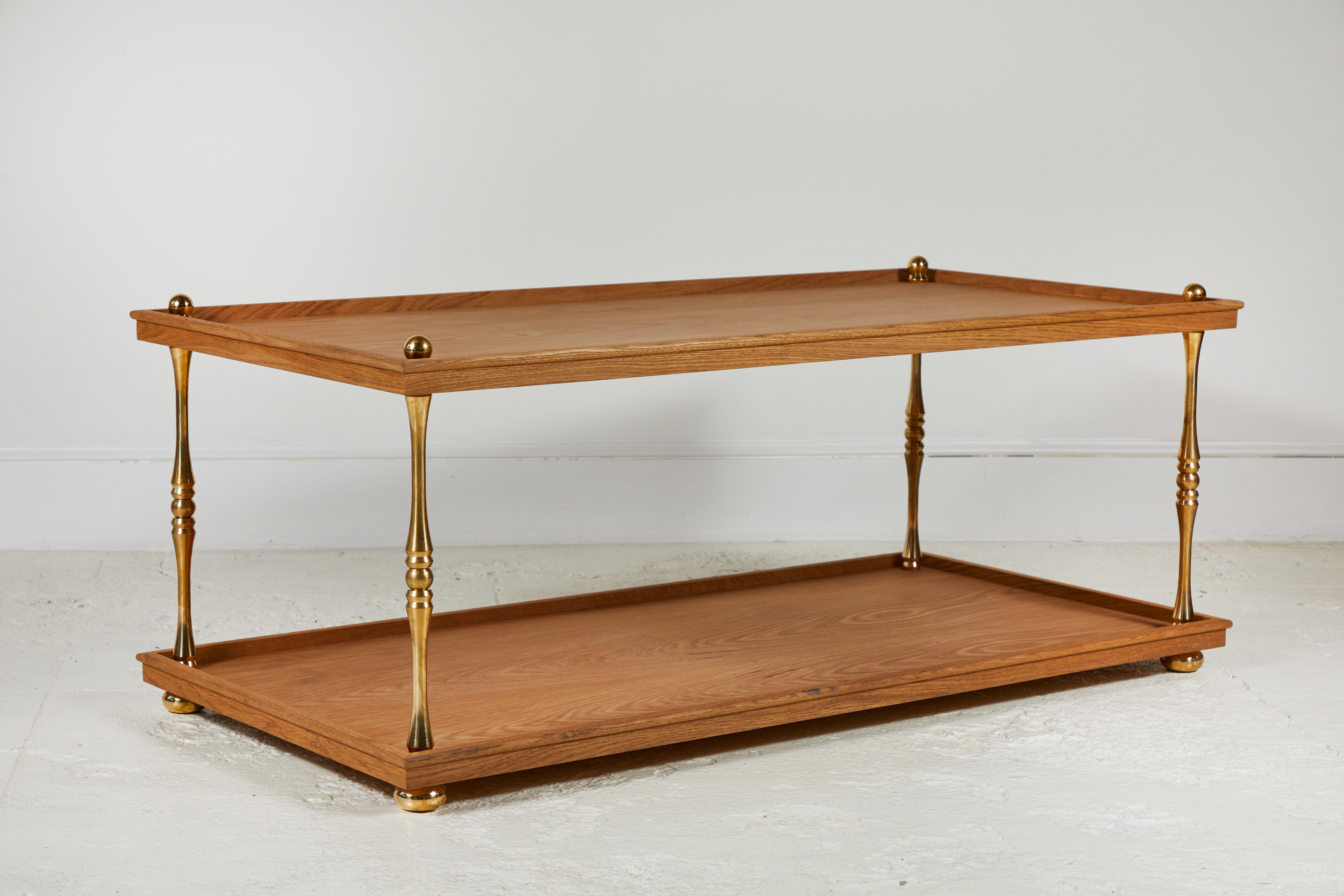 Nickey Kehoe collection turned brass cocktail table is made of two tiers solid natural oak held together with four solid unlacquered brass post. The table is finished with a beautiful crown lip.