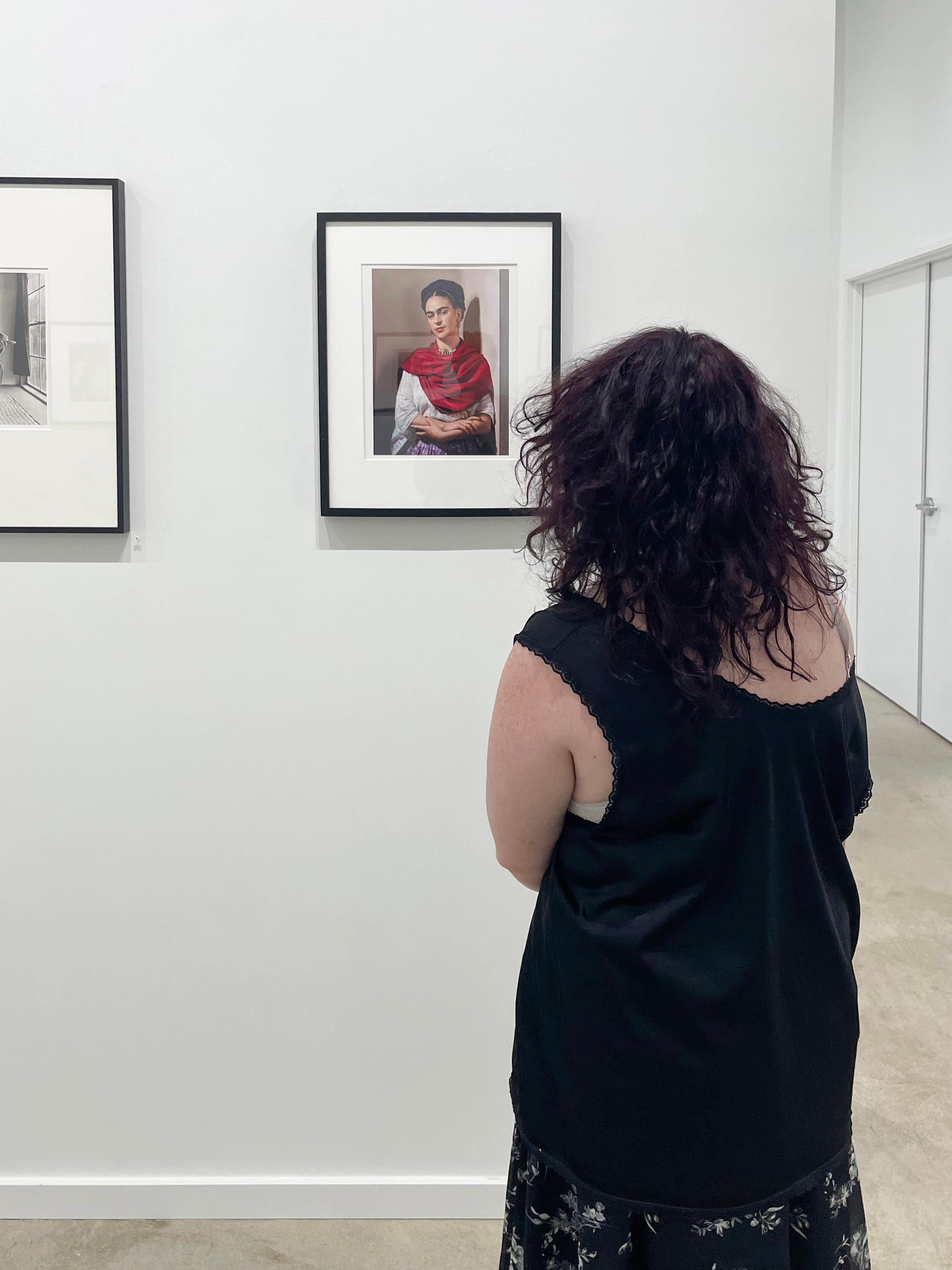 Frida Kahlo con Magenta Rebozo, Nueva York es un retrato en color de edición limitada de la pintora mexicana Frida Kahlo. Esta imagen icónica muestra a la mujer artista apoyada en una pared, con un pañuelo rojo enrollado alrededor de los