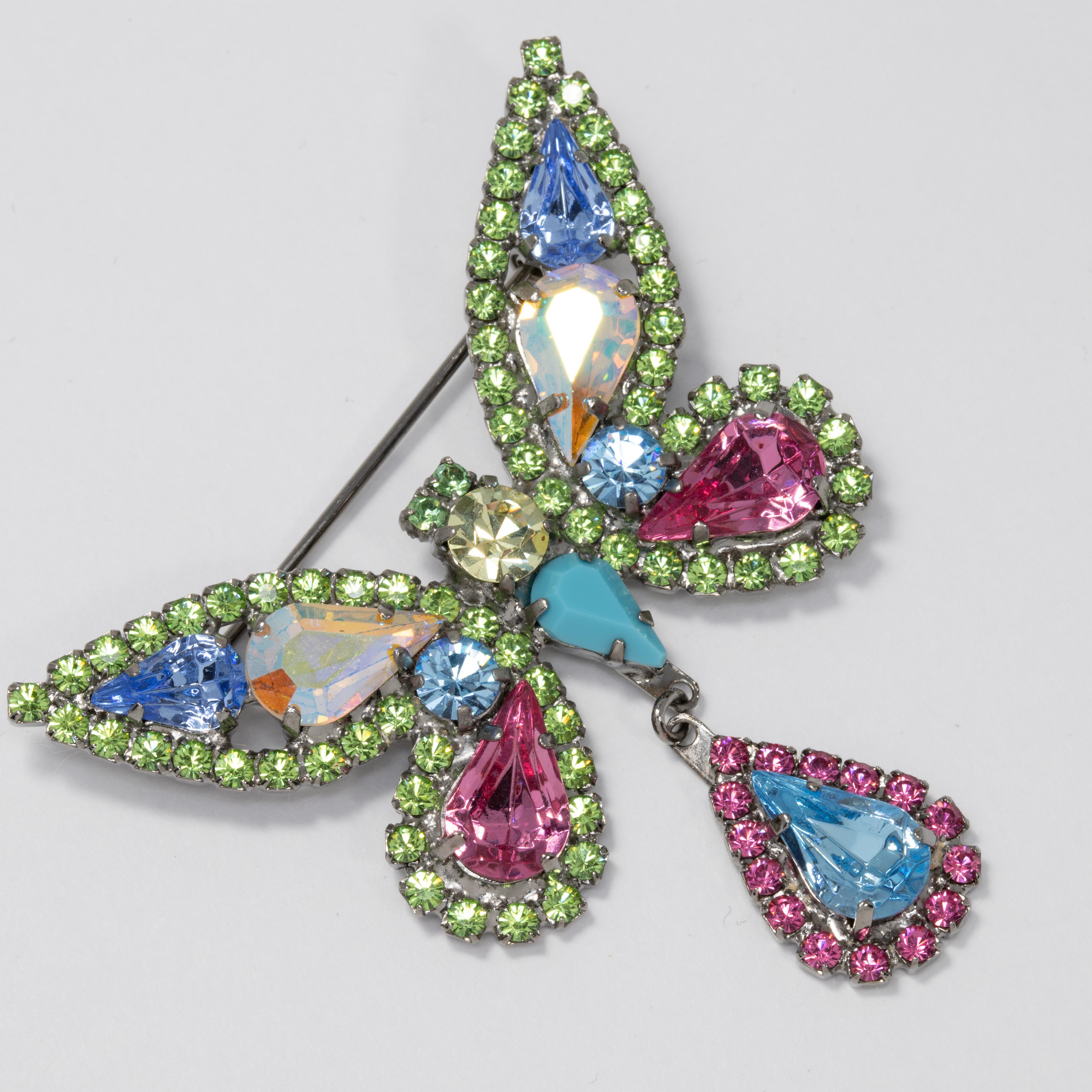 A sparkling butterfly pin brooch decorated with prong set teardrop and round-cut crystals. Features glittering peridot, rose, aquamarine, and aurora borealis colors.

Hallmarks: Nicky Butler, Made in England