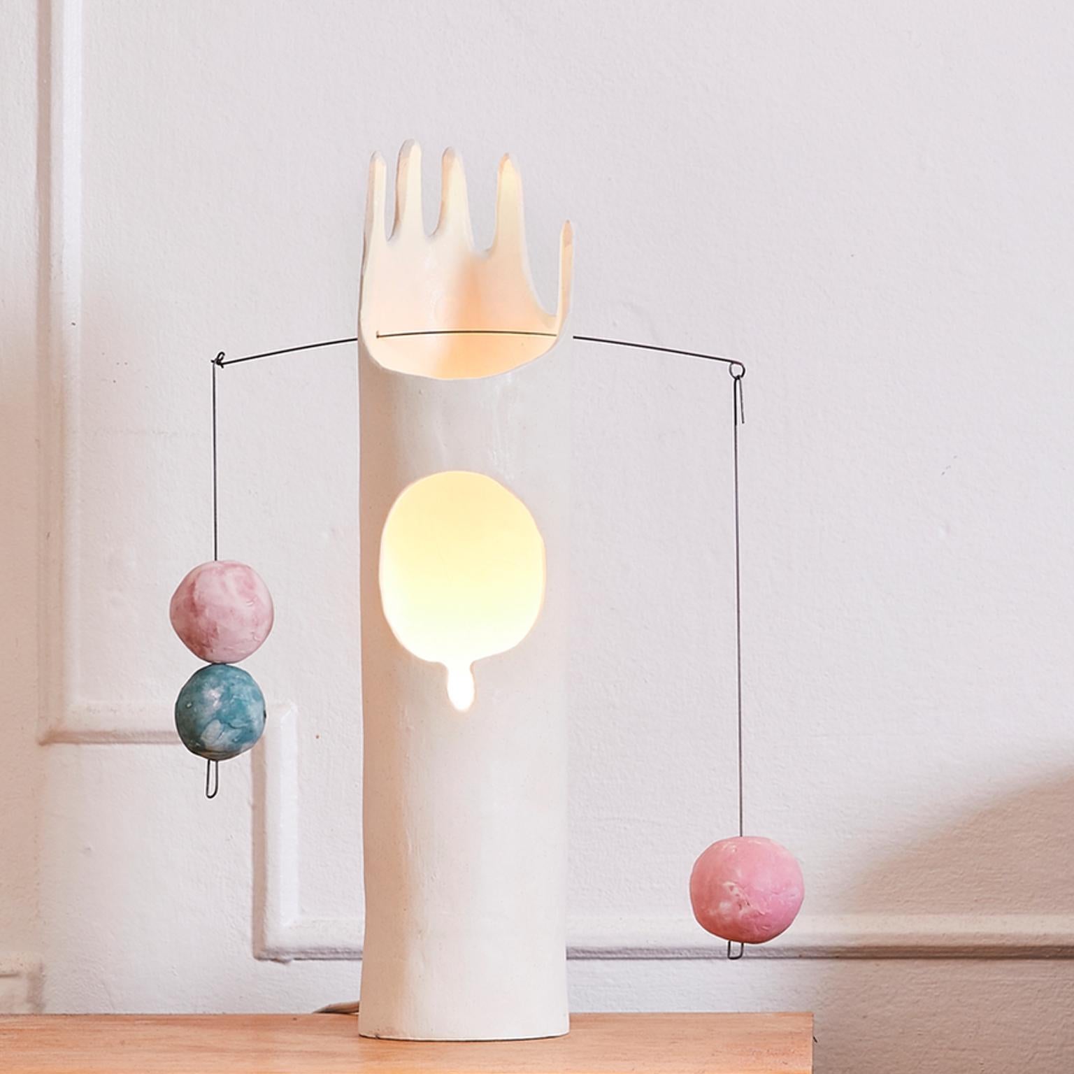 Nico is a hand-built sculptural ceramic table lamp that inspires the joy of working with hands through unpacking, assembling and balancing weights. The handmade ceramic globes and the hanging steel wire come fit right inside the belly of the