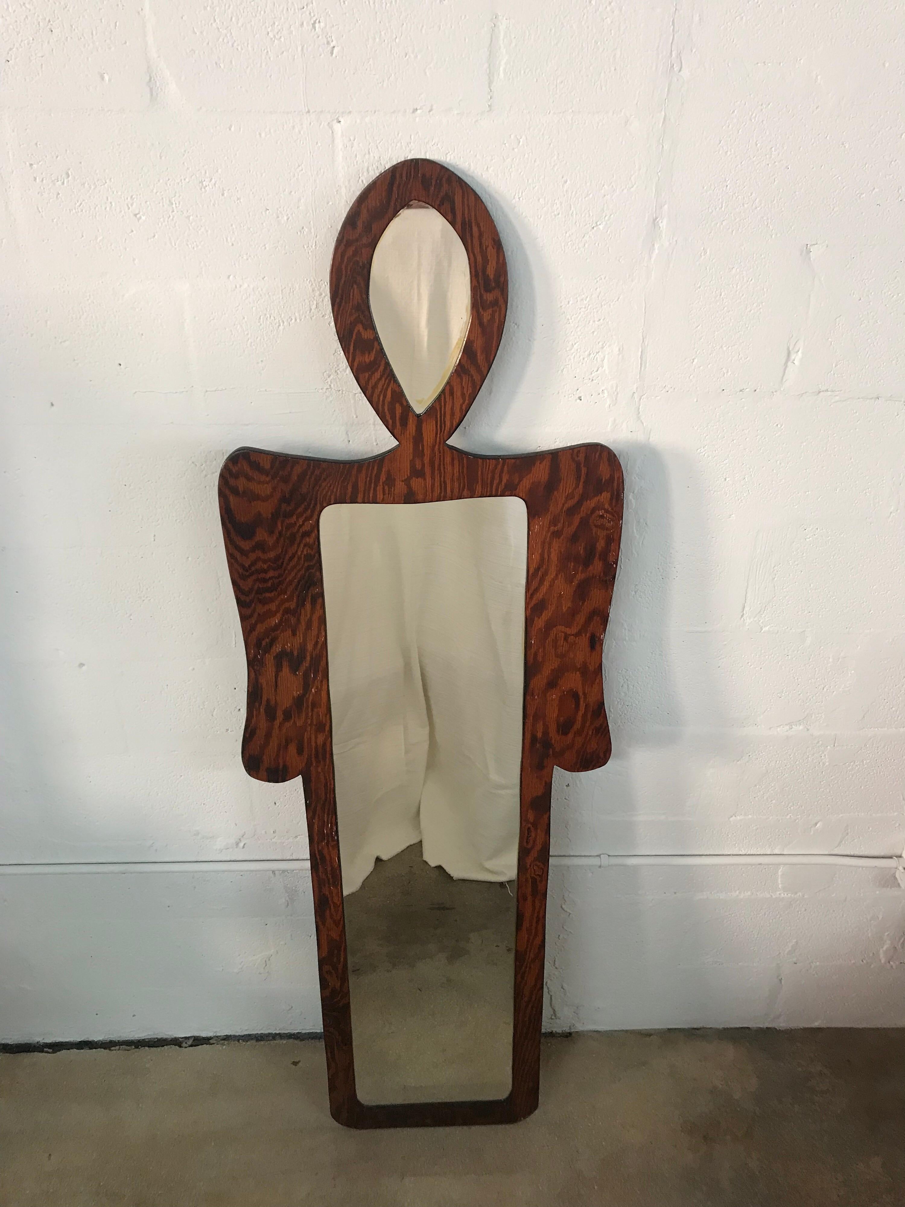 One of a kind postmodern figural wall or floor mirror depicting the shape of a standing man or woman with body and arms containing the main mirror and the head containing an additional mirror.  Rendered in handcrafted lacquered plywood with an inset