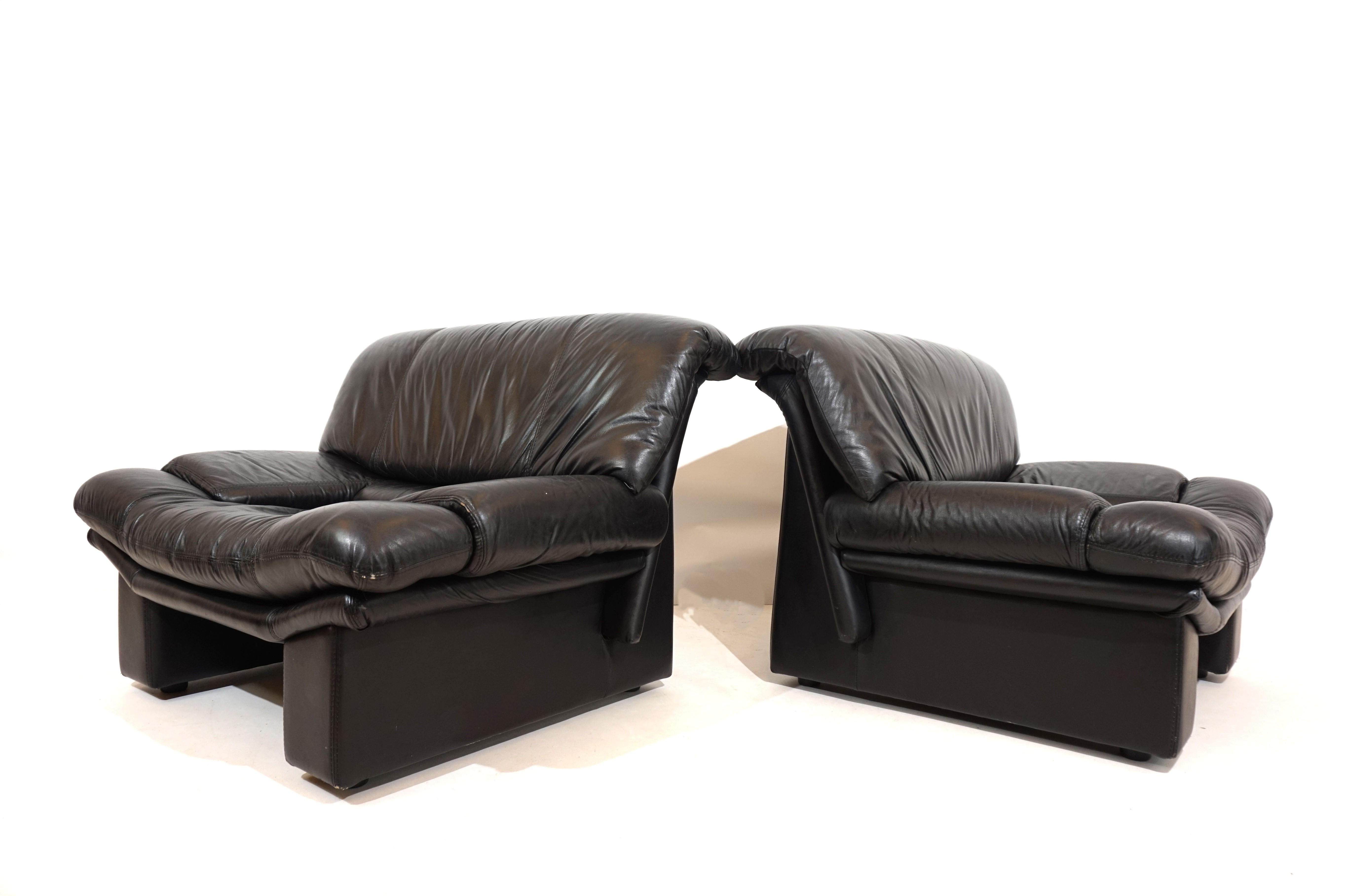 These two Ambassador leather chairs are in excellent condition. The soft black leather is flawless and shows only minimal signs of wear. The armchairs are characterized by the massive-looking columns on the back of the armchairs, which give them a