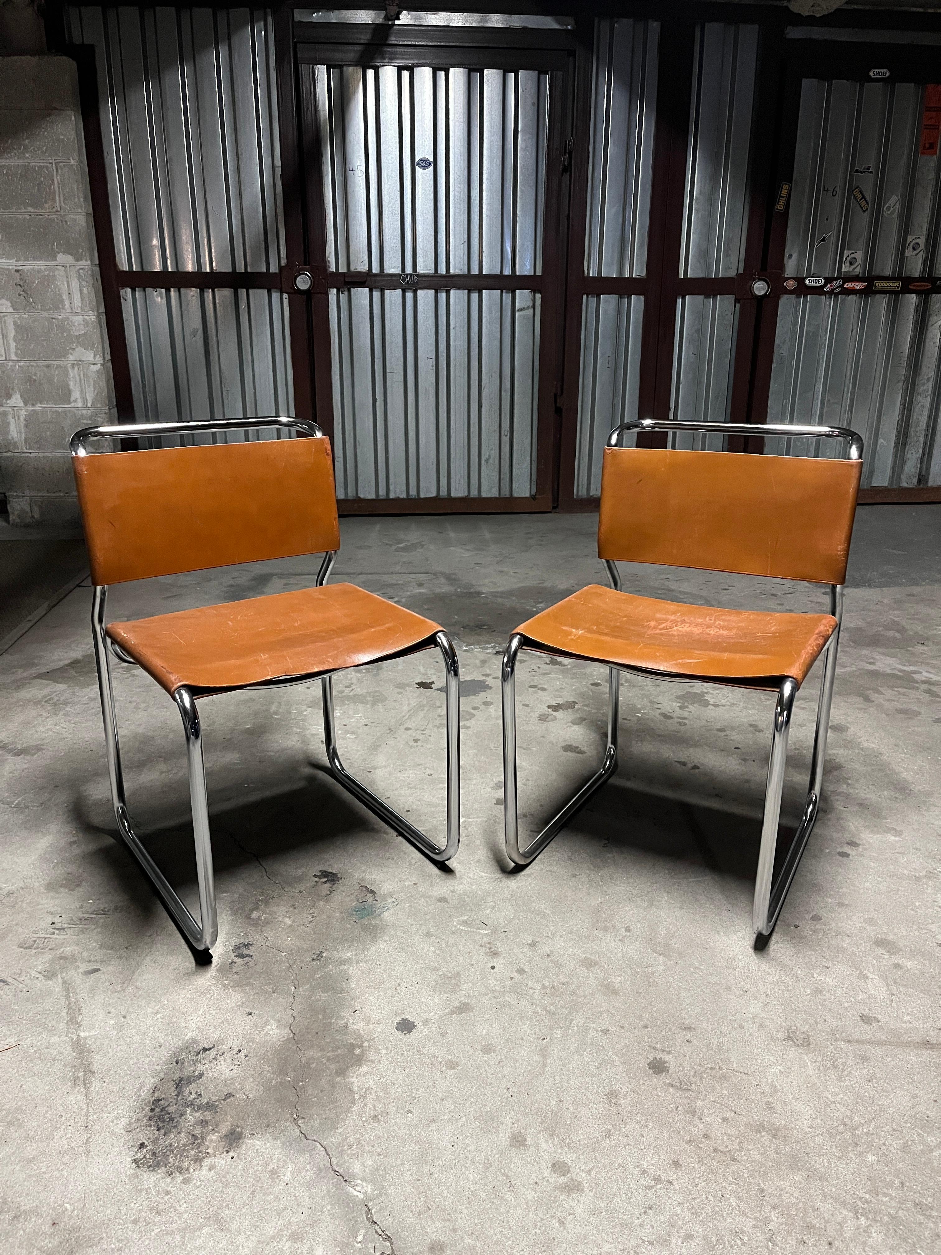 Nicos Zographos pair of leather and chrome steel cantilevered side chairs model Ch66 1970s. These chairs are heavy and beautifully crafted with a continuous tubular chrome steel frame and upholstered in high quality leather. 