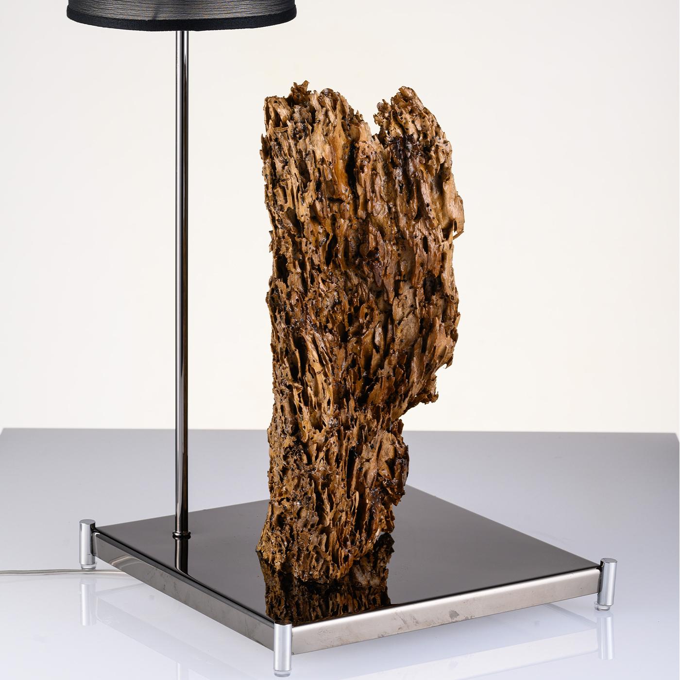 Exquisitely unique, Petros is the creation of lighting sculptures featuring sea wood from the Amalfi Coast. For the Nido D'Ape Sculpture, once carefully selected and prepared, the wood is set onto a base in reflective black stainless steel, engraved