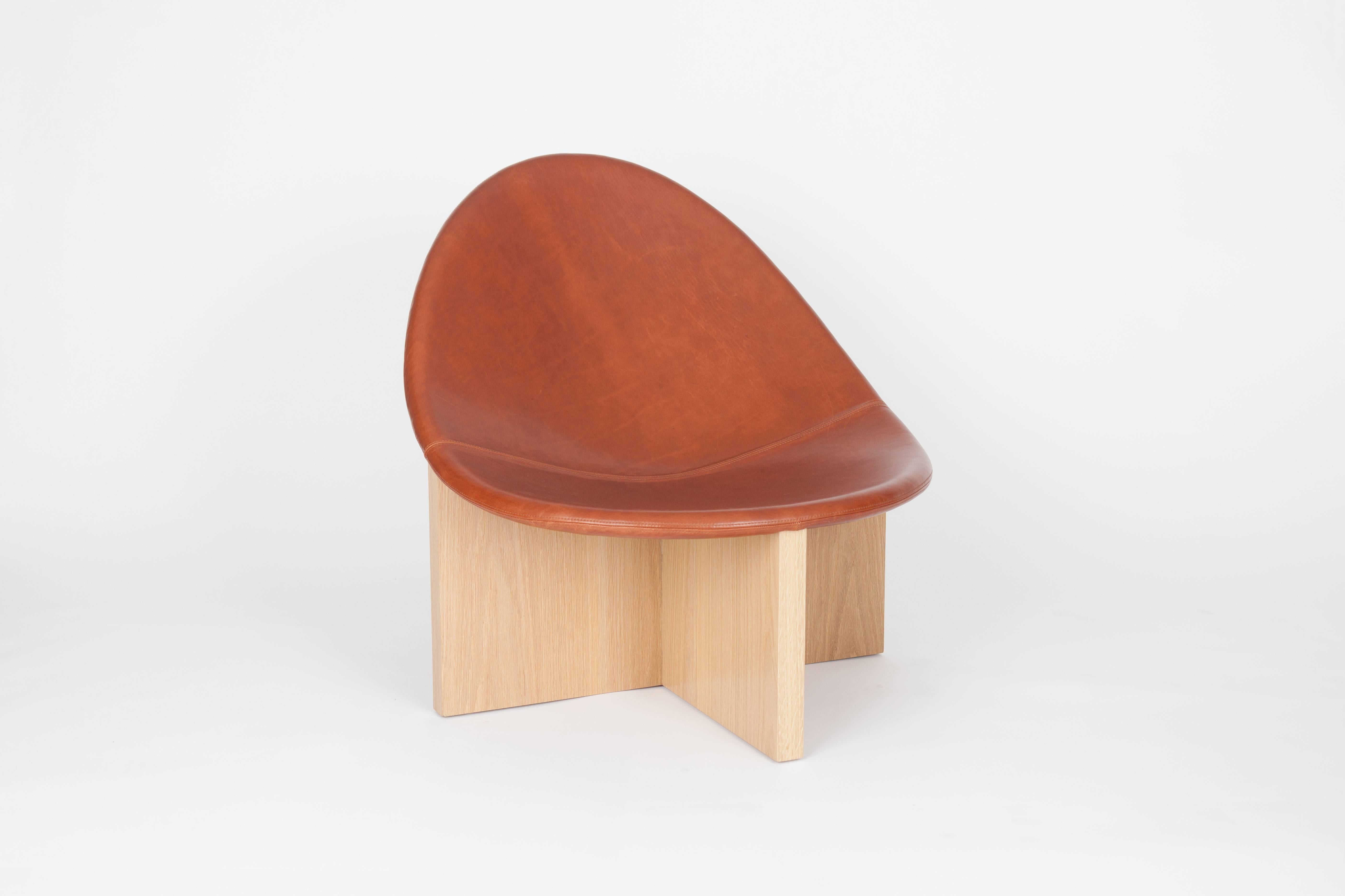 The NIDO Chair was the result of playing with the juxtaposition of shapes. The egg-like shape of the leather upholstered wood seat nesting in the cross shaped solid wood frame gives it the name NIDO, meaning nest in Spanish. The strong lines of the