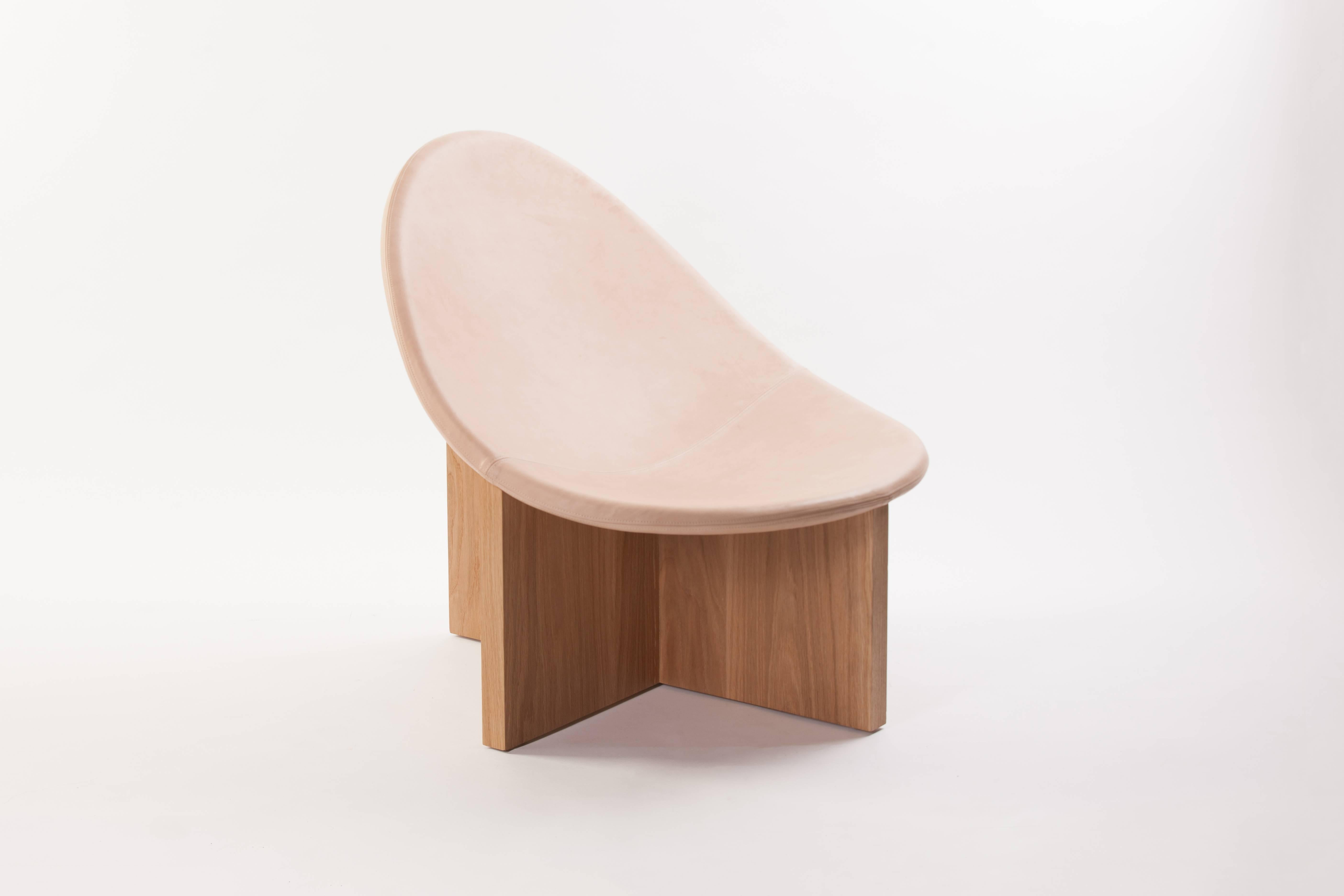 The Nido chair was the result of playing with the juxtaposition of shapes. The egg-like shape of the leather upholstered wood seat nesting in the cross shaped solid wood frame, gives it the name Nido, meaning nest in Spanish. The Nido's strong lines