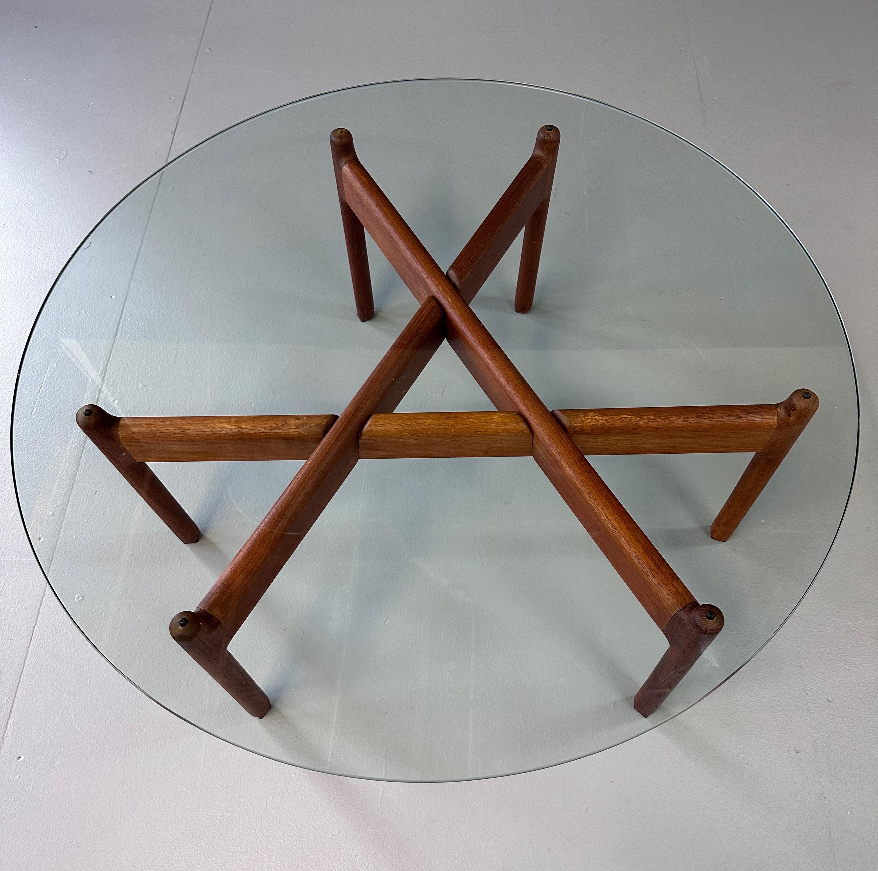 Very nice and rare coffee table designed by Niels Bach, Denmark 1960. This table has a solid teak base existing in 3 parts, easy to assemble. With a hardened glass top. Very nice sculptural shaped table.