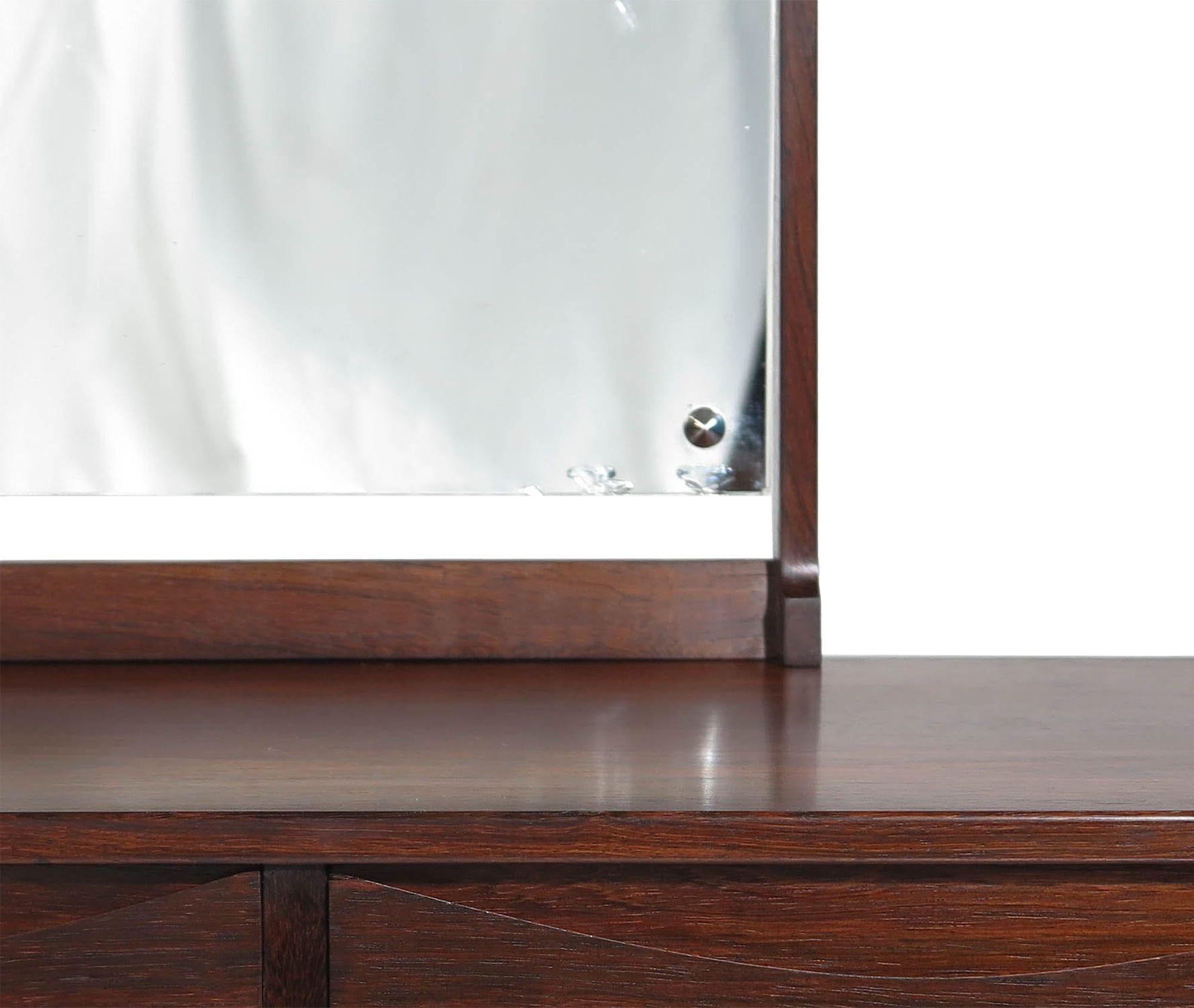 Brazilian rosewood vanity by Niels Clausen, 1958, Denmark. This petite vanity with tilting mirror is crafted of beautifully grained Brazilian rosewood with a raised edge, two pull-out drawers with half-moon-shaped carved handles, and a mirror. The