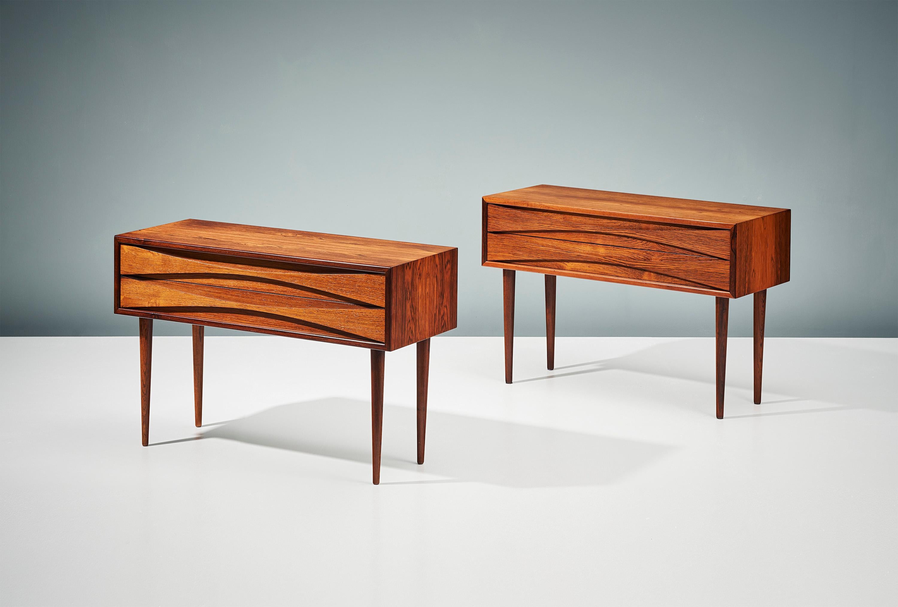Pair of bedside cabinets, circa 1960

Rosewood cabinets by Niels Clausen for his own company NC Møbler produced in Odense, Denmark, circa 1960. Each wide cabinets has two slim drawers with elegant scalloped drawer-pulls and solid turned and