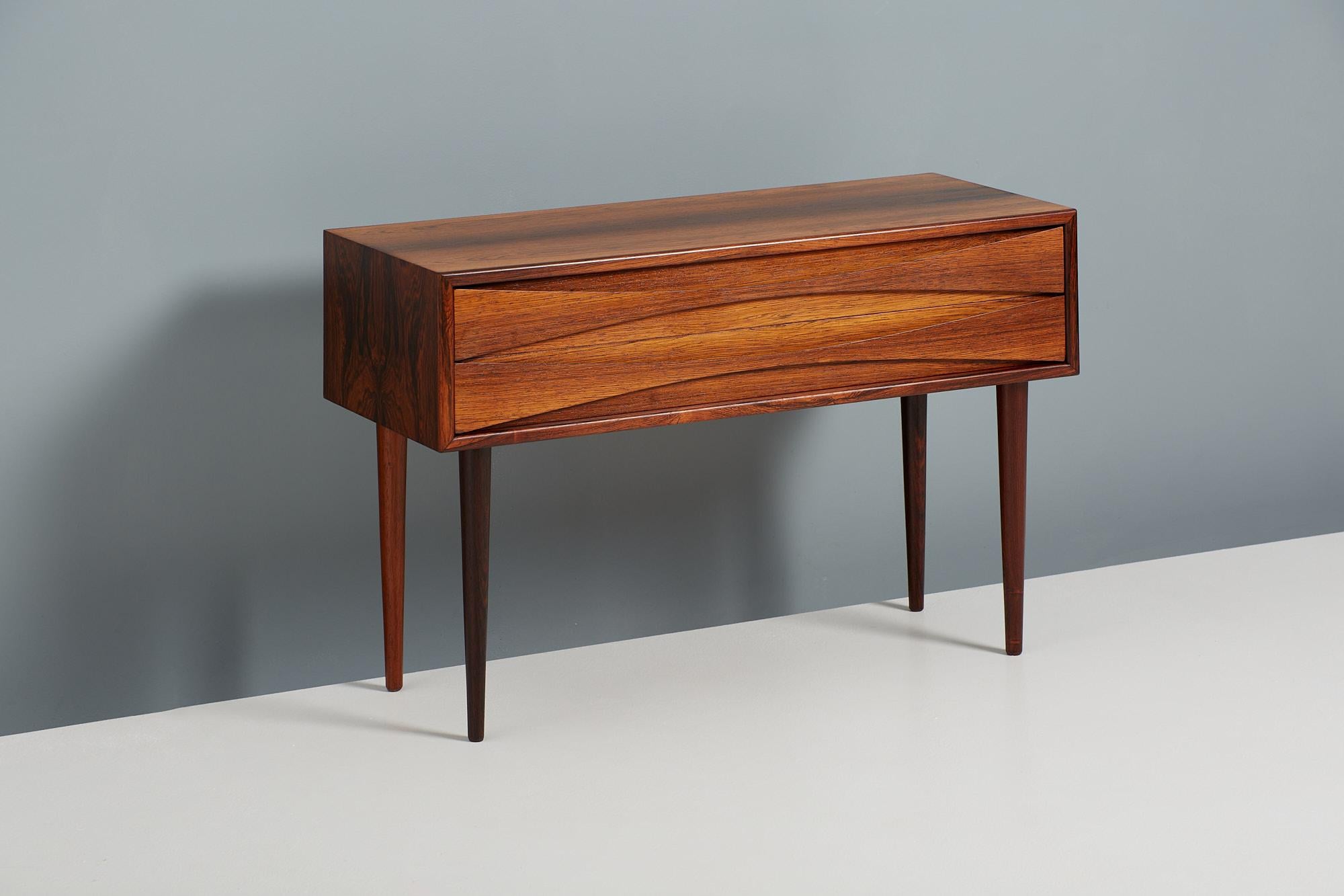 Niels Clausen

Low Chest, c1960

Rosewood chest by Niels Clausen for NC Mobler, Odense, Denmark. Produced c1960. Two drawers with trademark scalloped pulls and solid tapered legs.

Measures: width 80 cm 
Depth 32 cm 
Height 54 cm.