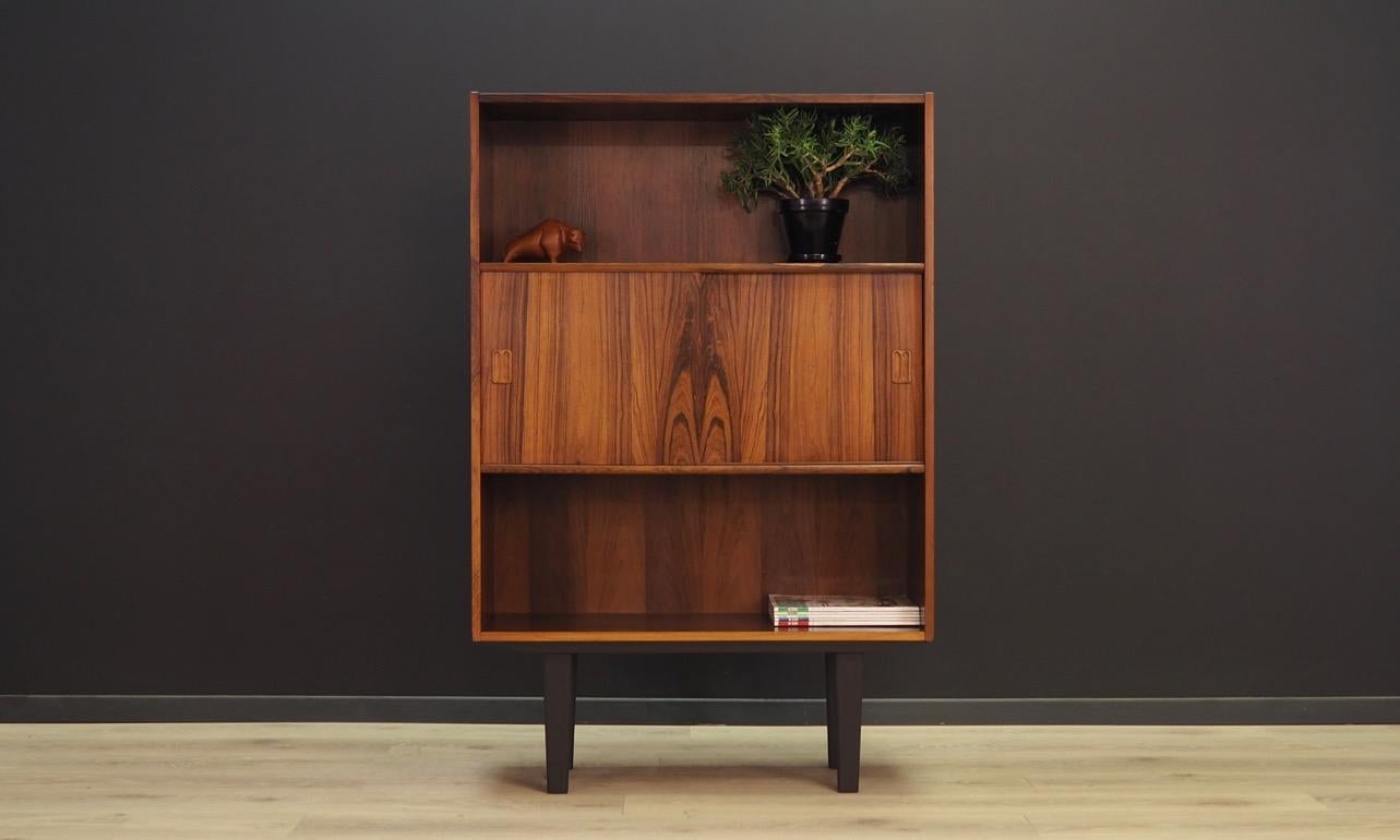 A phenomenal bookcase - library from the 1960s-1970s. Designed by Niels J. Thorsø. Minimalistic form, brilliant workmanship. The surface of the furniture covered with rosewood veneer. Shelves behind sliding doors. Maintained in good condition (minor