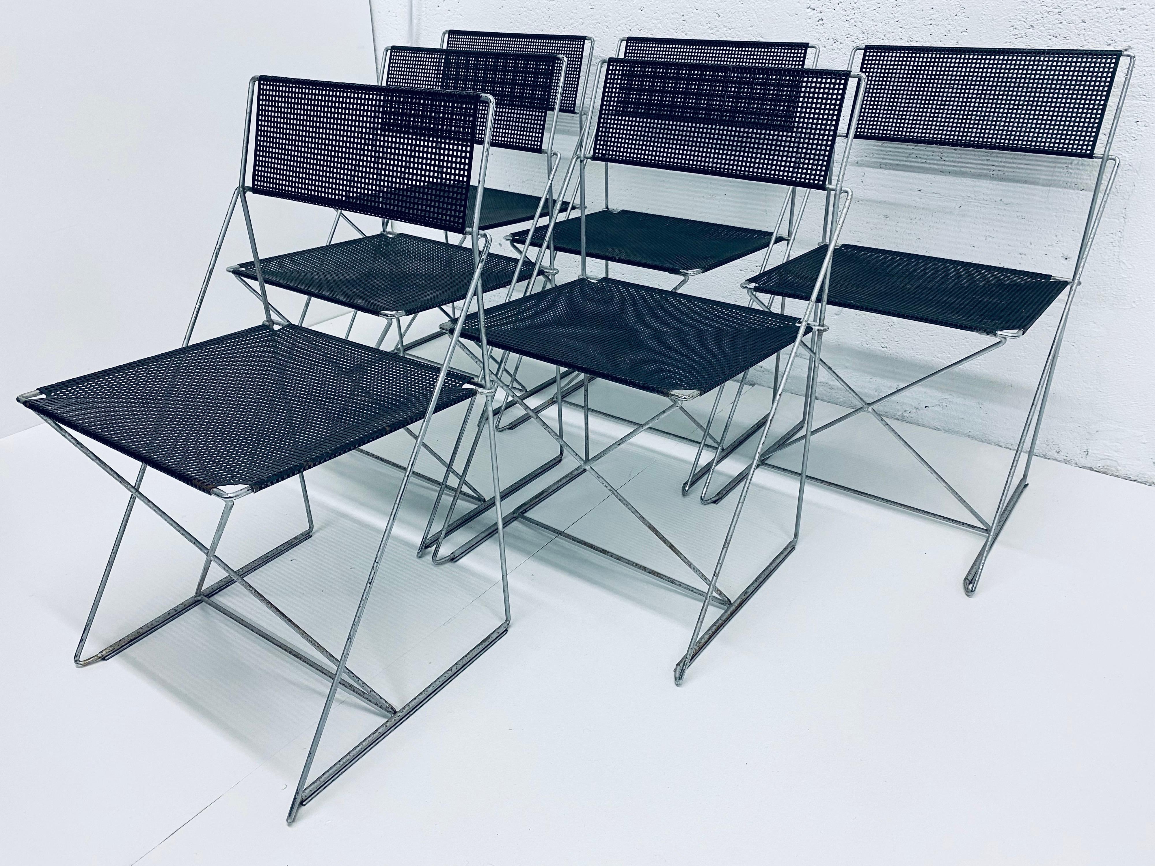 Set of 6 dining chairs in X-line, made of steel rods and black enameled perforated steel backs and seats. Designed by Niels Jorgen Haugesen for Magis. These chairs are in original condition with wear and are stackable. Made in Denmark.