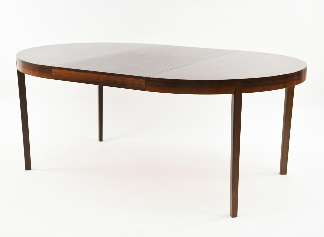 A handsome circular dining table with two leaves designed by Niels Koefoed for Hornslet Mobler, circa 1960s. This elegant table is crafted of high quality rosewood with a stunning color and grain to match the attractive, refined Scandinavian Modern