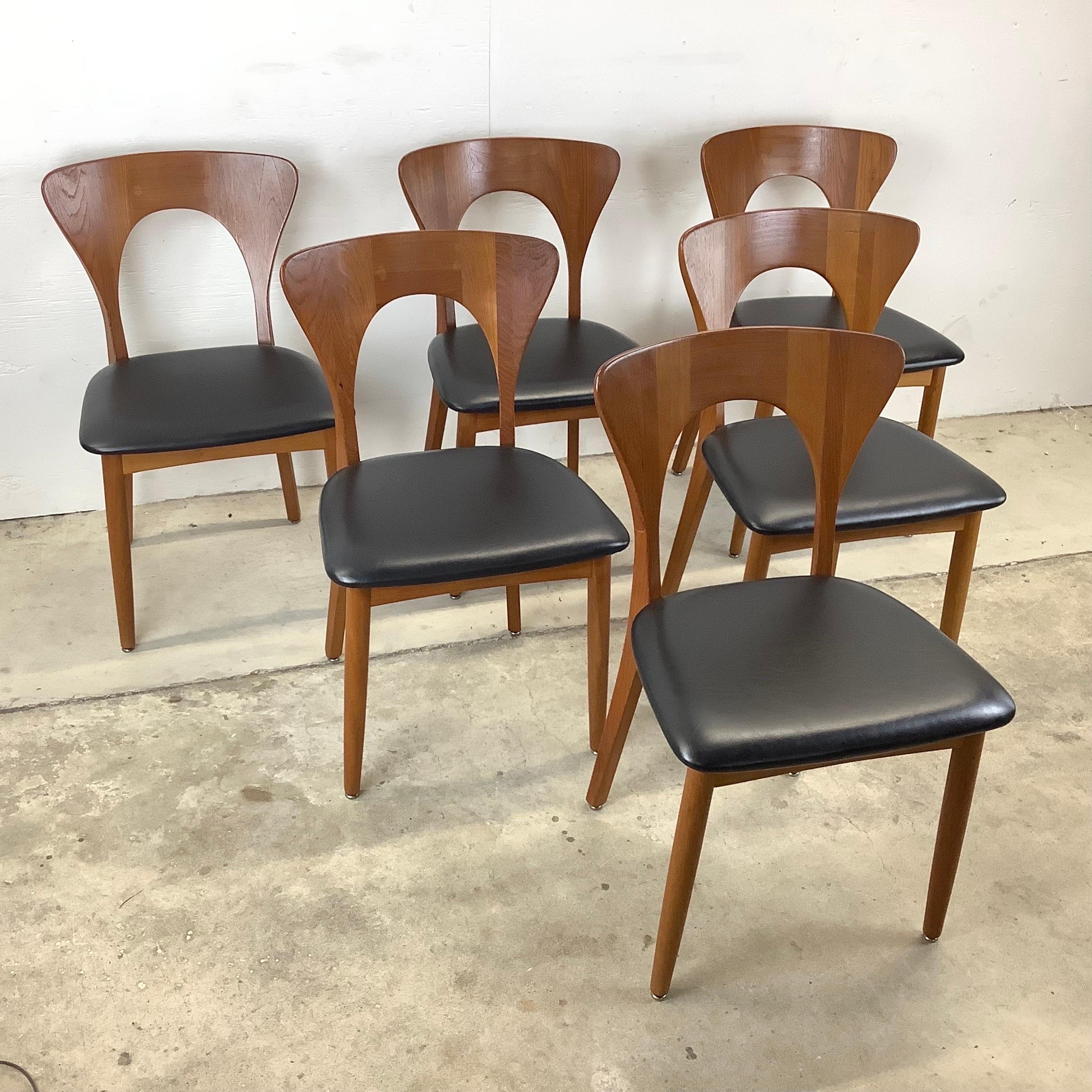 This striking set of Mid-Century Modern dining chairs feature iconic sculptural teak seat backs from Niels Koefoed for Koefoed Hornslet. The Scandinavian Modern appeal of the vintage teak finish, comfortable proportions, and impressive craftsmanship