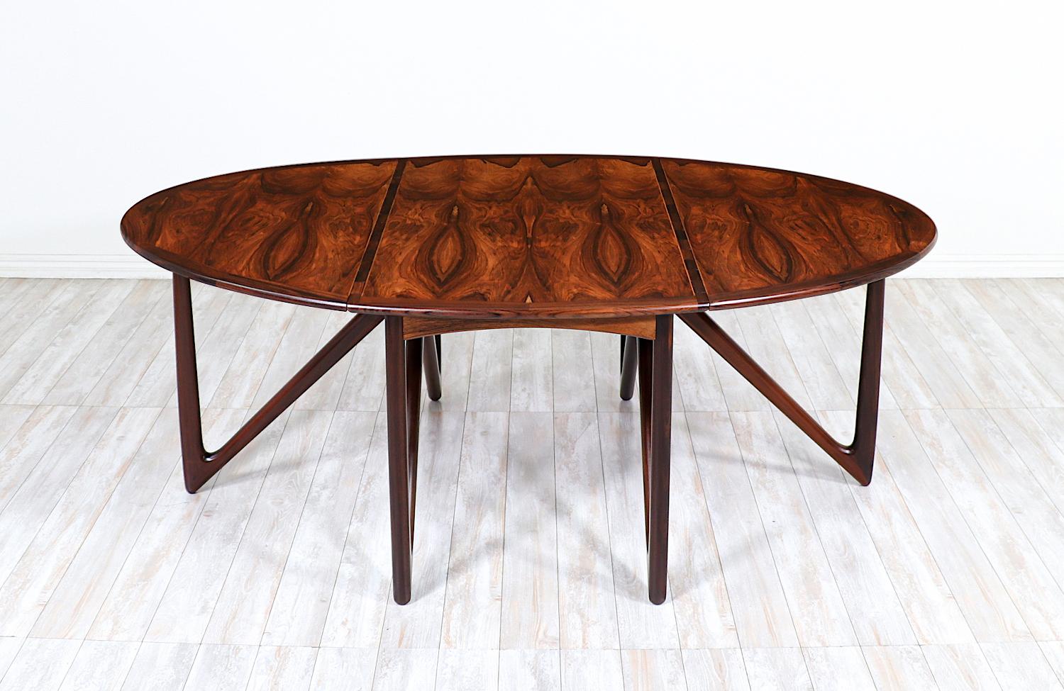 Versatile dining table designed by Danish designer Niels Koefed in collaboration with the workshop of Koefoeds Møbelfabrik during the 1960s. Crafted from Brazilian rosewood, this table functions as a console, writing, or dining table with a