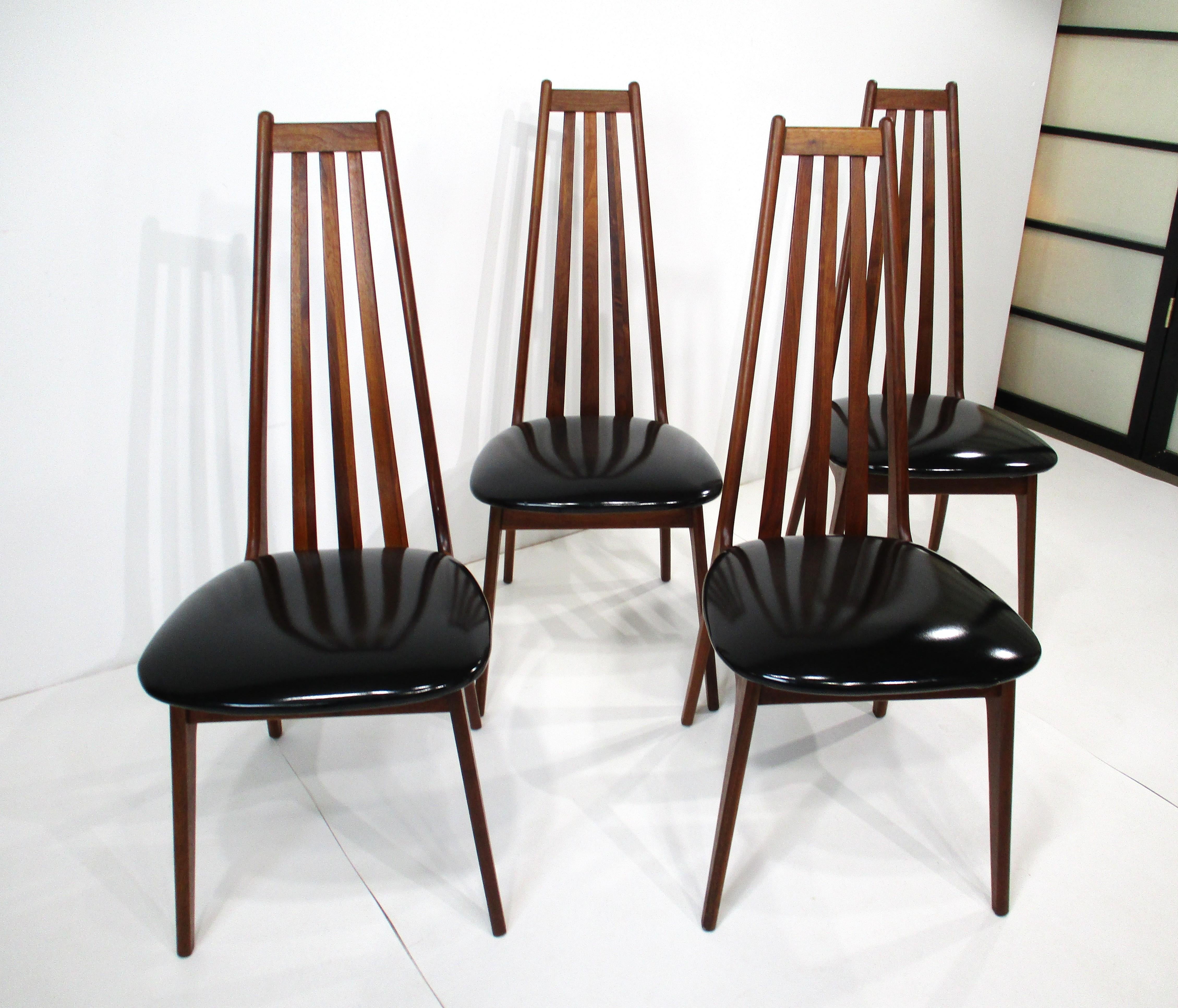 Un set di quattro sedie da pranzo con schienale alto in noce con sedute originali in vernice nera che conferiscono un'estetica unica. Queste sedie con struttura in noce massiccio sono molto comode e hanno un aspetto fresco e leggero, progettato alla