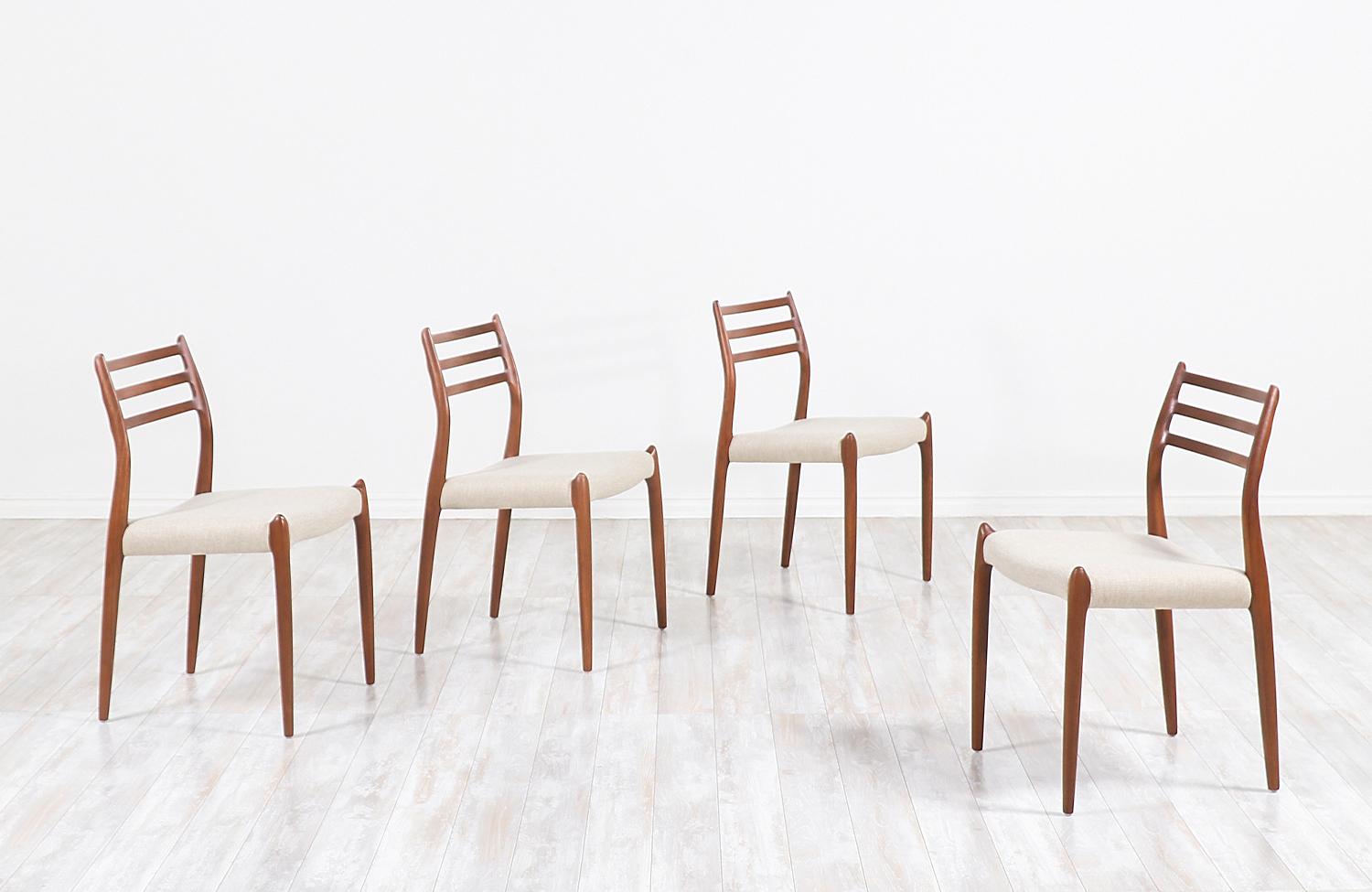 Set of four modern dining chairs designed by Niels O. Møller for J.L. Møllers in Denmark, circa 1960s. All four chairs feature an ergonomic design and are comprised of solid walnut wood with new light tweed upholstery and high-density foam cushions