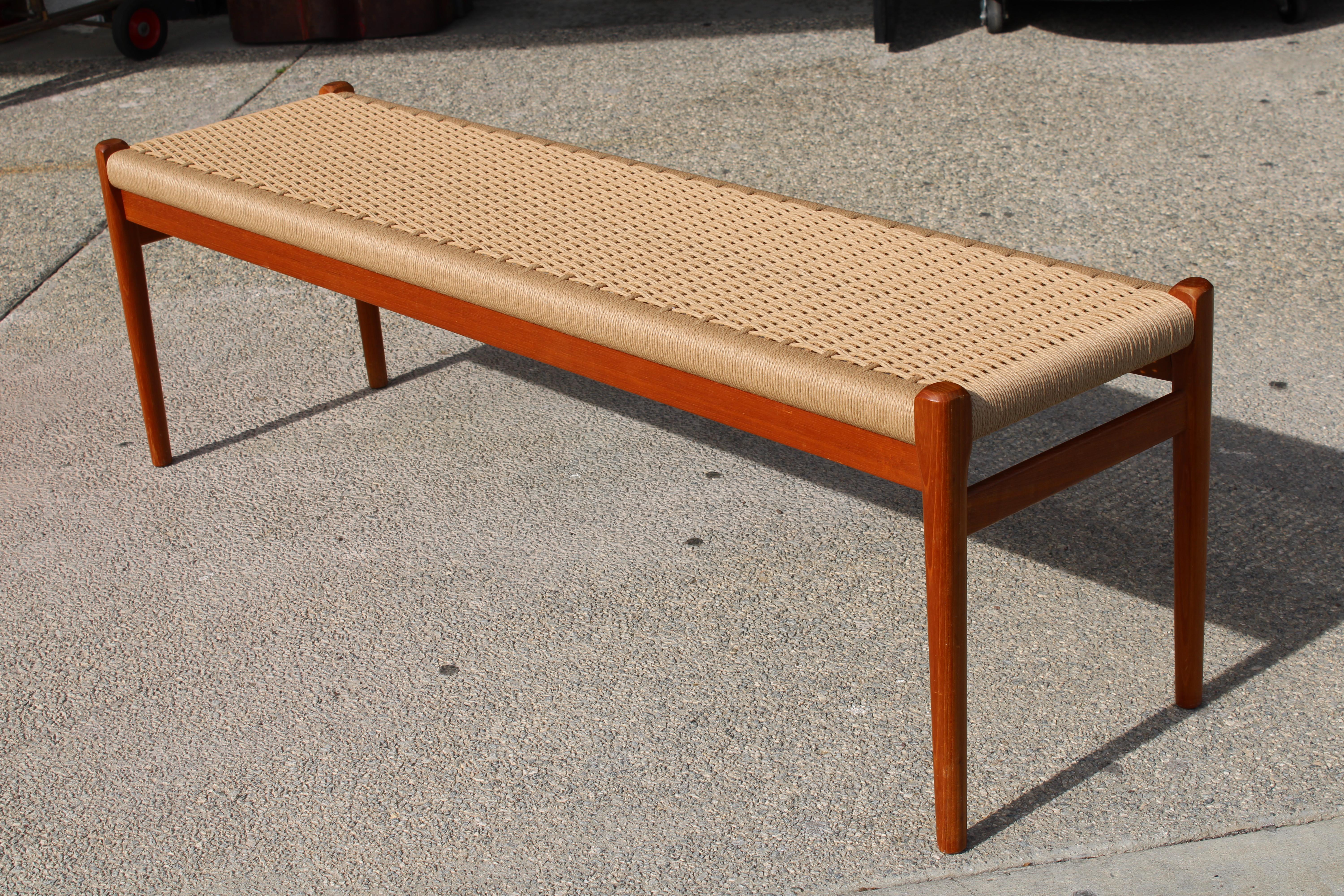 Iconic Danish modern paper cord and teak bench designed by Niels Otto Moller and produced by J.L. Mollers Mobelfabrik in Denmark. Manufacturers medallions J L Moller Models, Made in Denmark and FurnitureMakers Danish Control on the underside.  Bench