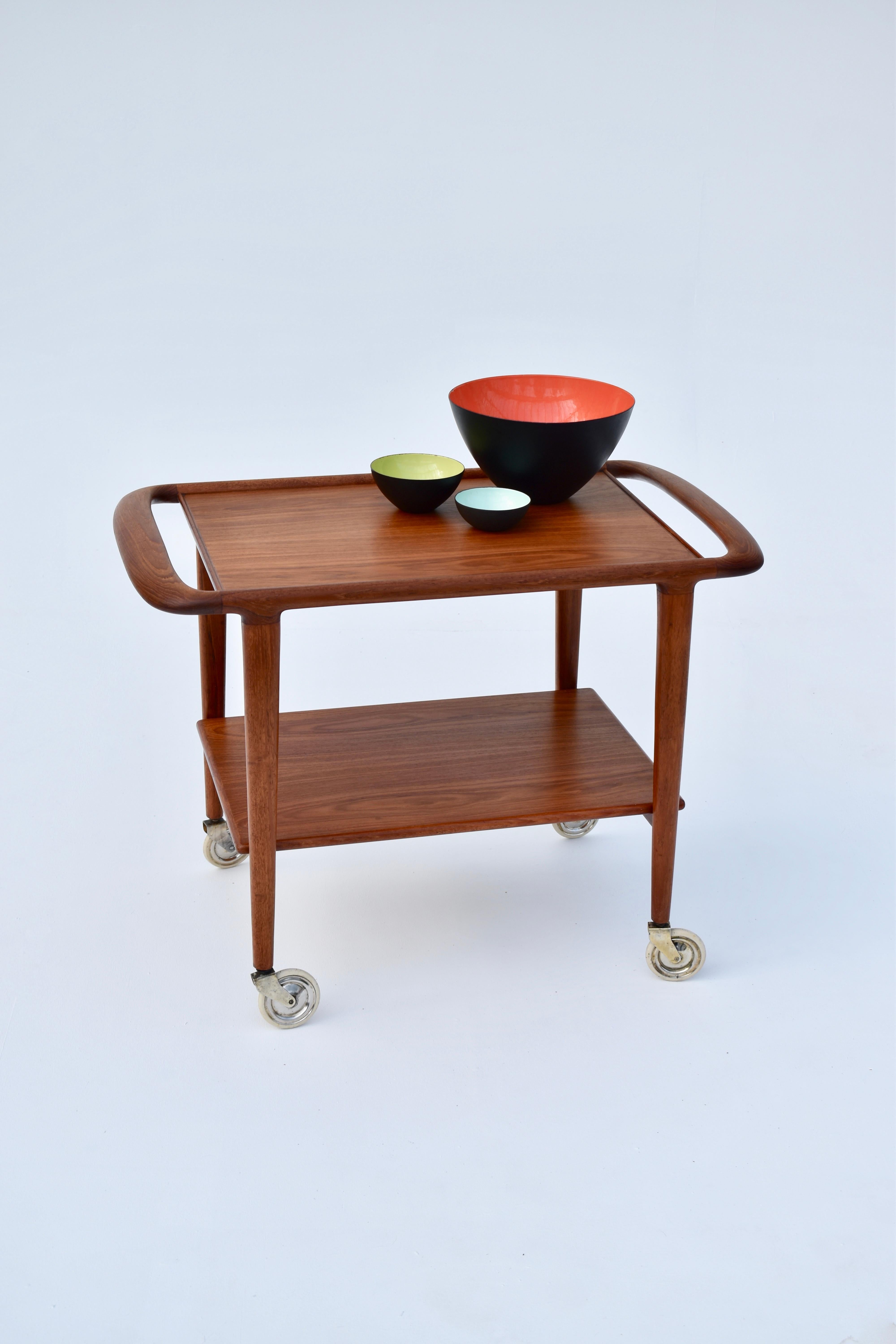 Very hard to find bar cart designed by Niels Moller in 1959.

Produced by J L Moller this example is executed in teak. An incredibly graceful design and very functional too, it can be used as a very attractive side table or hall table if not