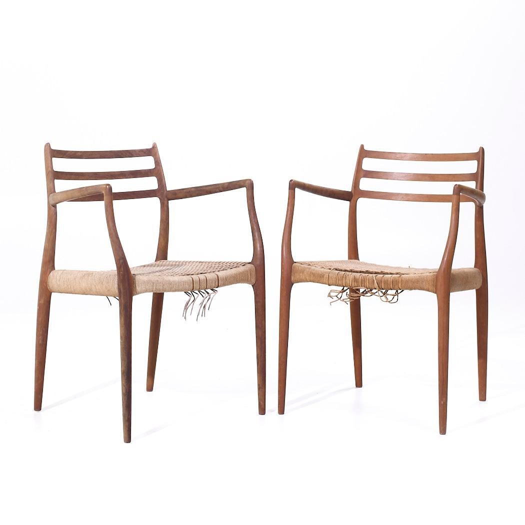 Paire de chaises de capitaine danoises en teck du milieu du siècle dernier, Niels Moller modèle 62

Chaque chaise mesure : 21,75 de large x 20,25 de profond x 31,25 de haut, avec une hauteur d'assise de 17,5 et une hauteur d'accoudoir de 27,5