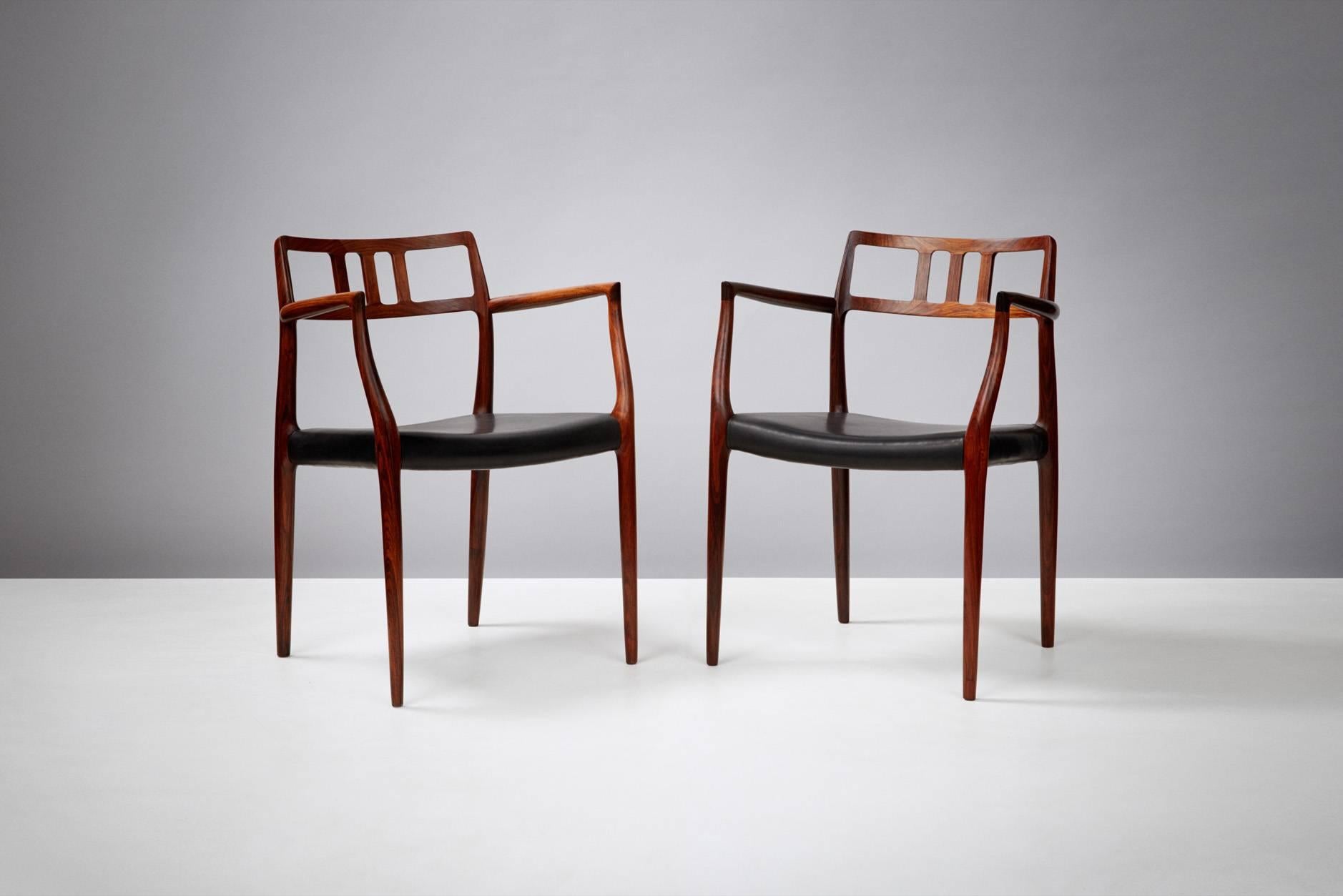 Pair of Model 64 rosewood armchairs produced by J.L. Mollers Mobelfabrik, Denmark, circa 1966. Newly covered in aniline black leather.