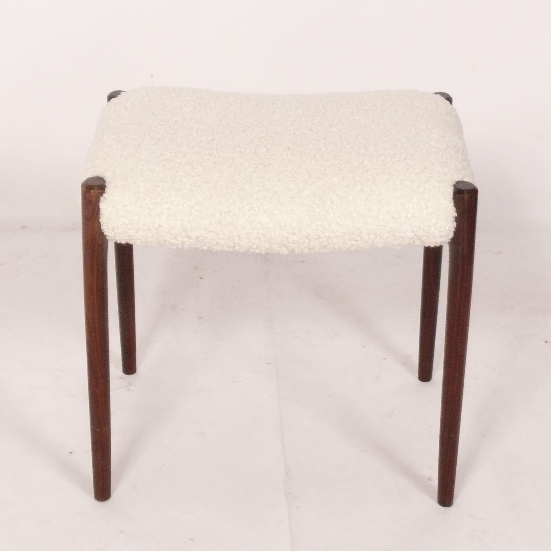 Danish Modern Rosewood Stool, designed by Niels Moller, Denmark, circa 1960s. It has recently been reupholstered in a plush ivory boucle fabric. It is a versatile size and could be used as a stool or end table. 